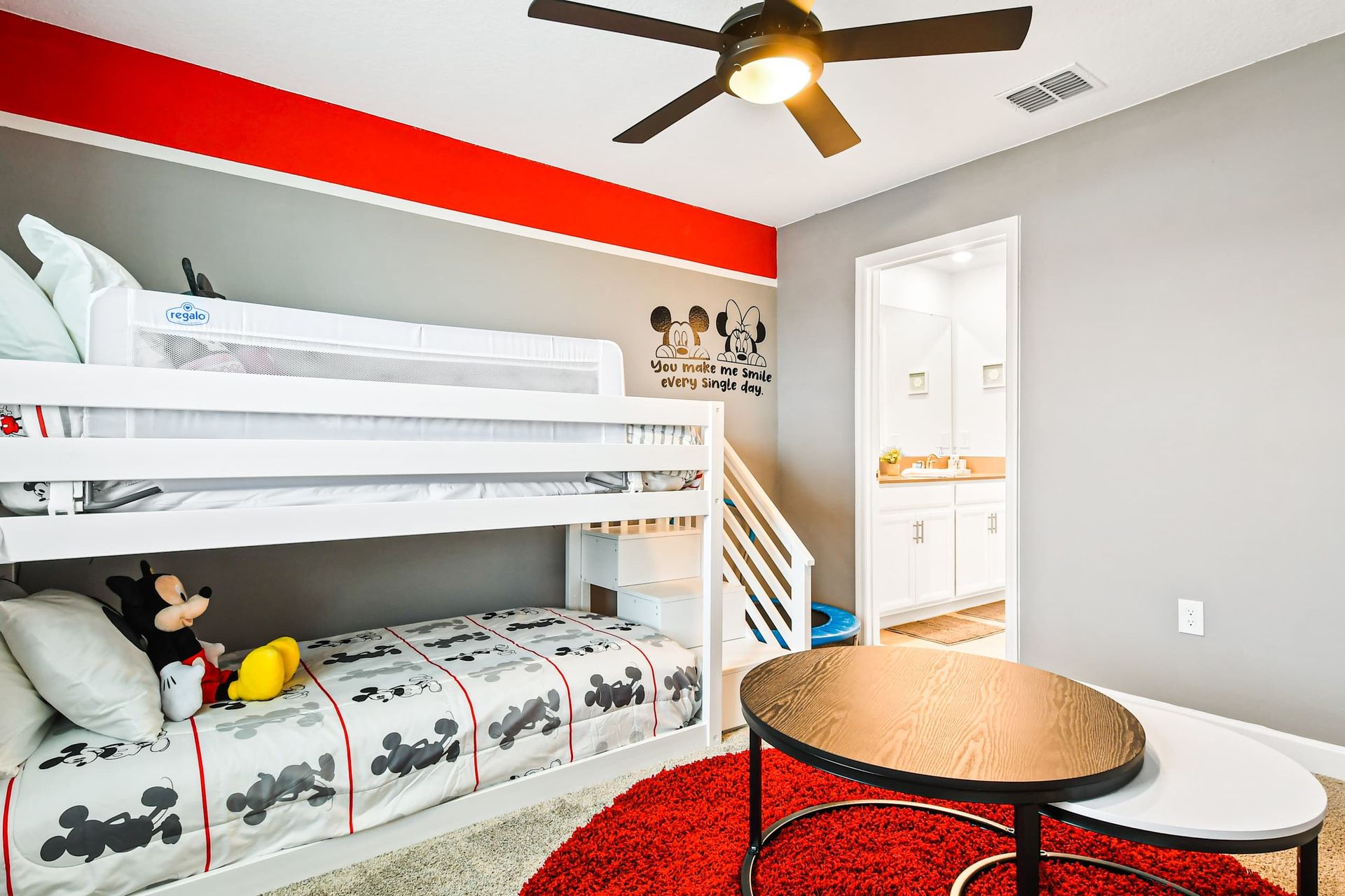 Whimsical kids’ room with bunk beds, fun decor, and private bathroom access.