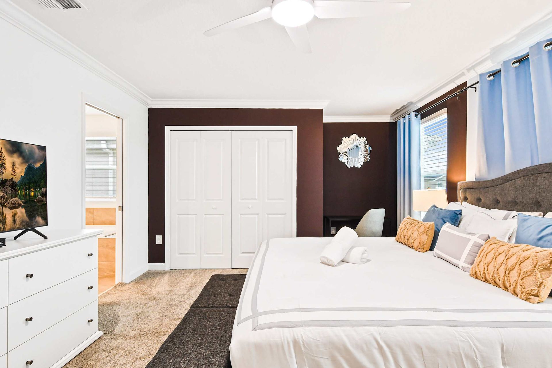 Elegant master suite with king bed, smart TV, ensuite bath, and cozy workspace.