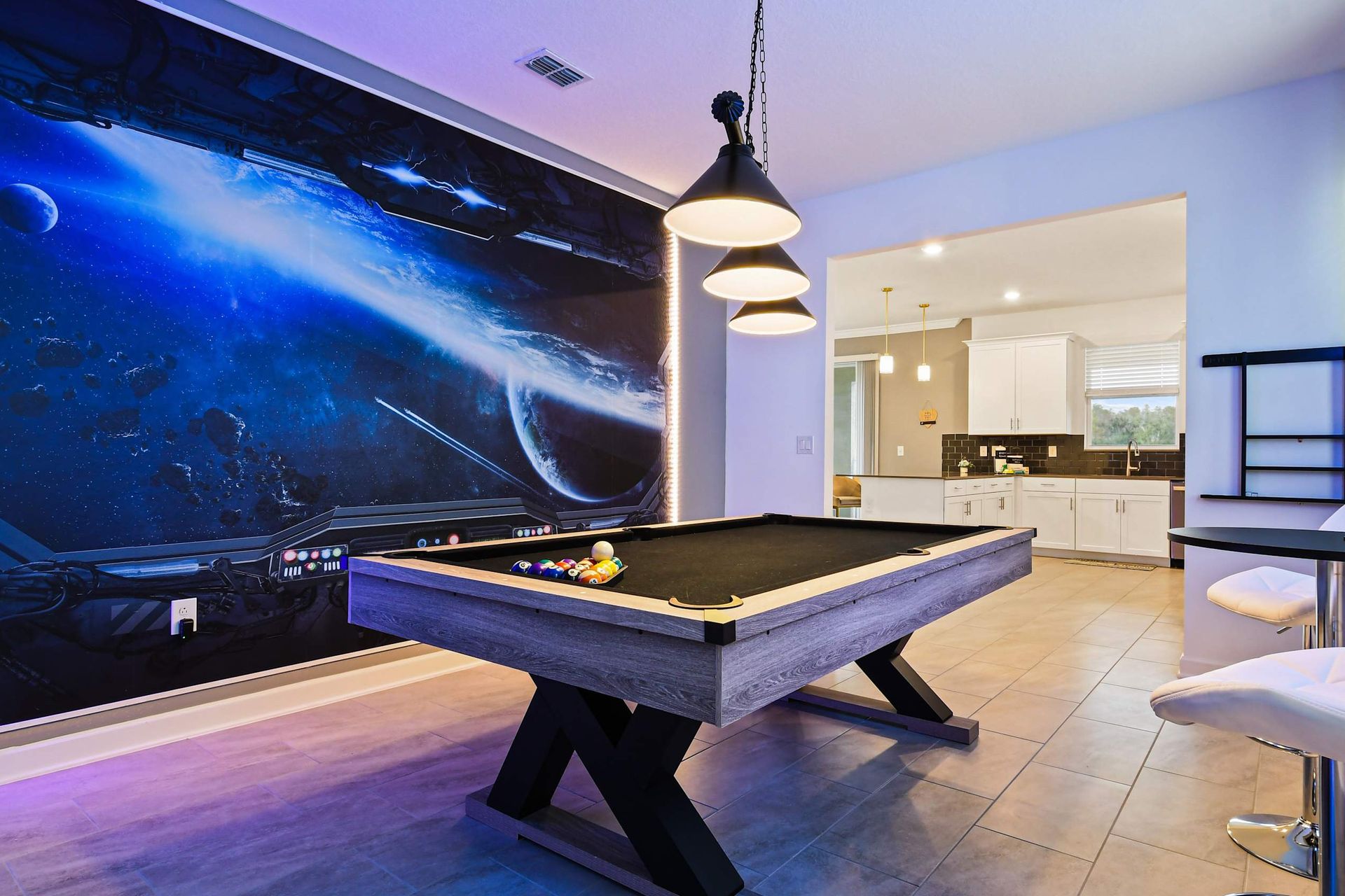 Epic game room with space-themed mural, sleek pool table, and LED lighting vibes.