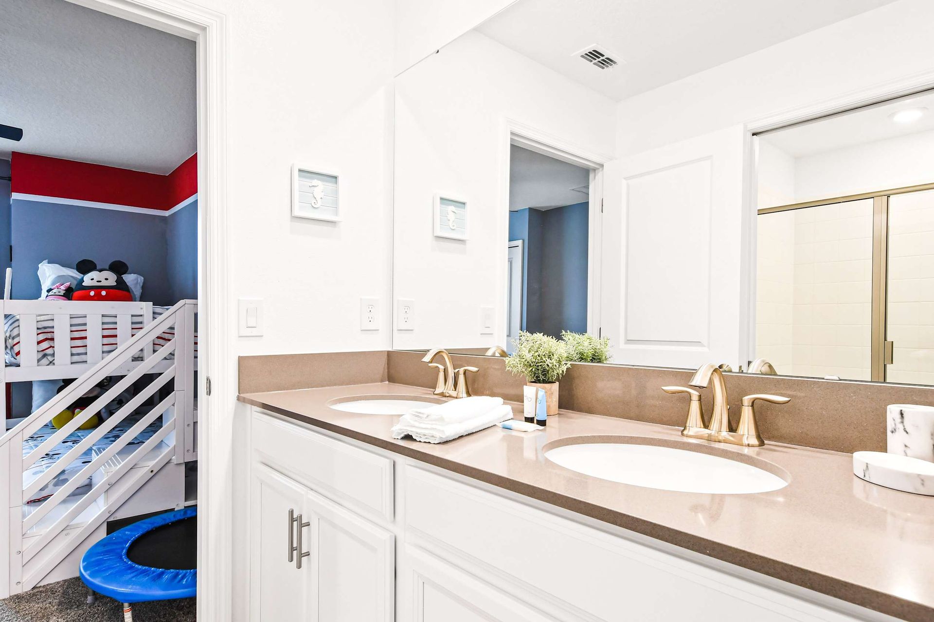 Jack-and-Jill bathroom with dual sinks, bright design, and kid-friendly access.