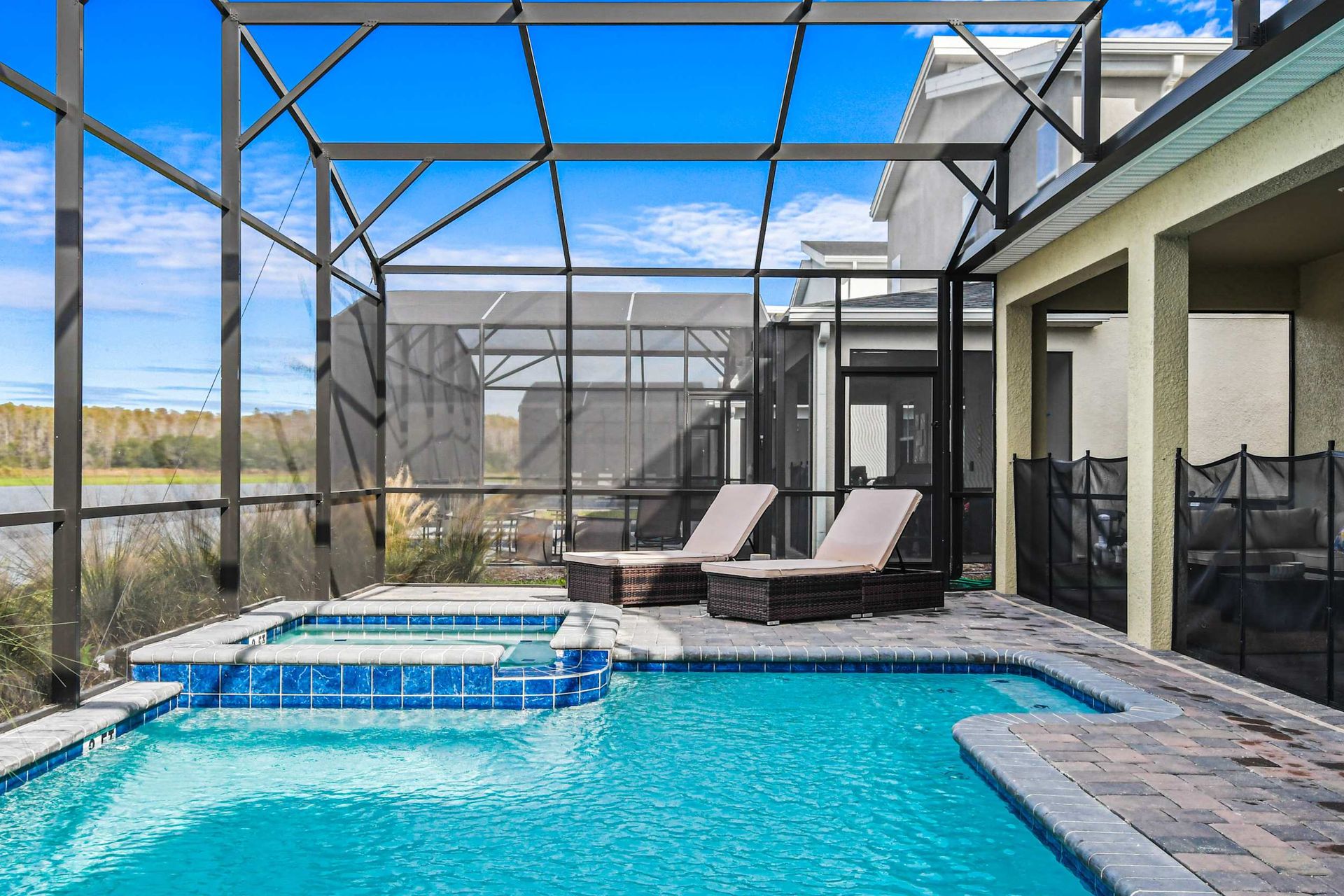 Relax in the screened pool and spa with lake views, loungers, and covered seating.