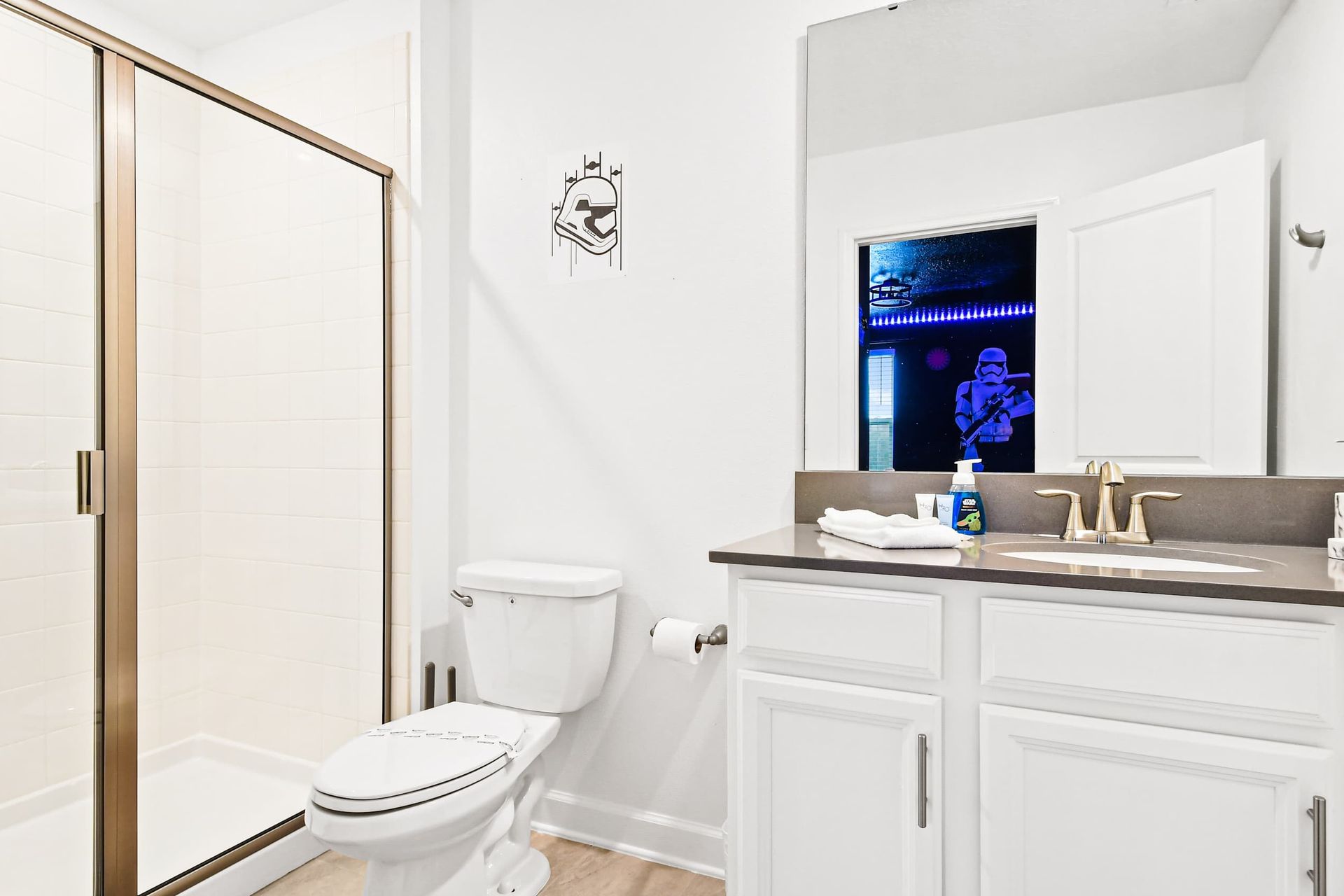 Modern themed bathroom with walk-in shower, sleek vanity, and galactic details.