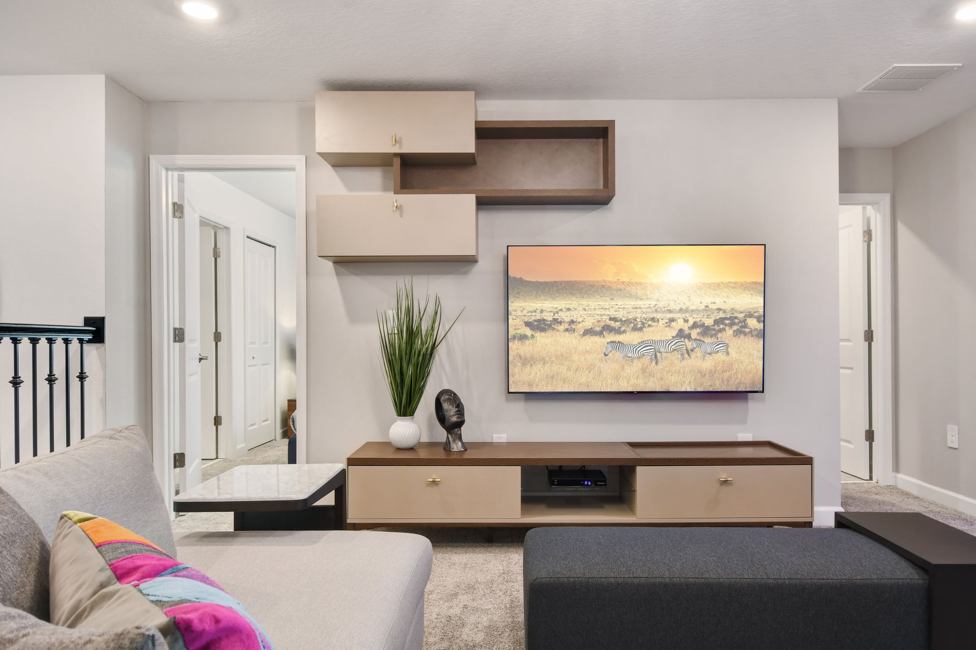 Cozy upstairs lounge with smart TV, modern decor, and comfy sectional seating.