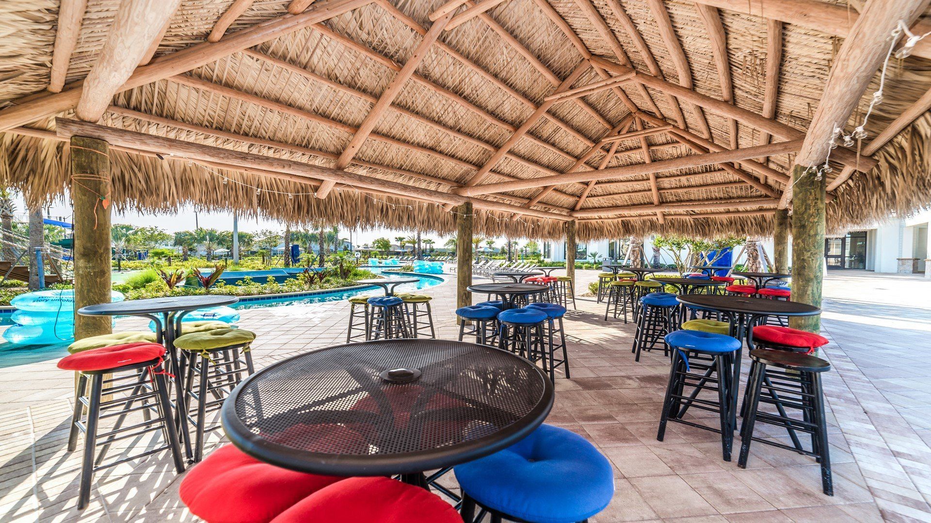 Relax in style by the resort lazy pool on comfortable table and chairs setup, offering you the perfect spot to unwind and soak up the serene ambiance.