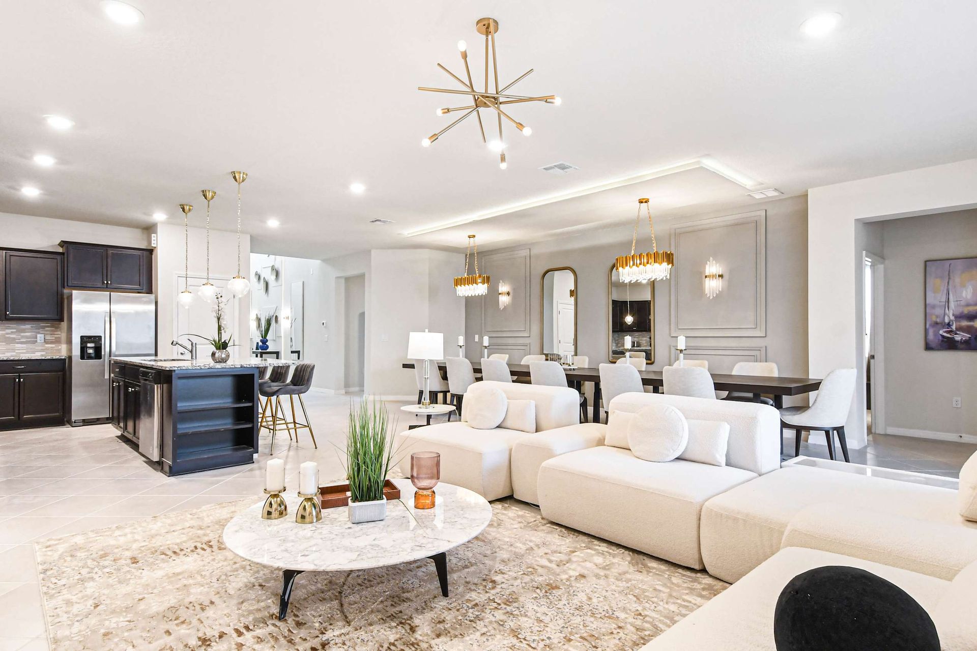 The spacious and elegantly designed living room serves as the heart of the home. It features a large, comfortable sofa set centered around a modern fireplace. The room is adorned with tasteful art and has a large, flat-screen TV.