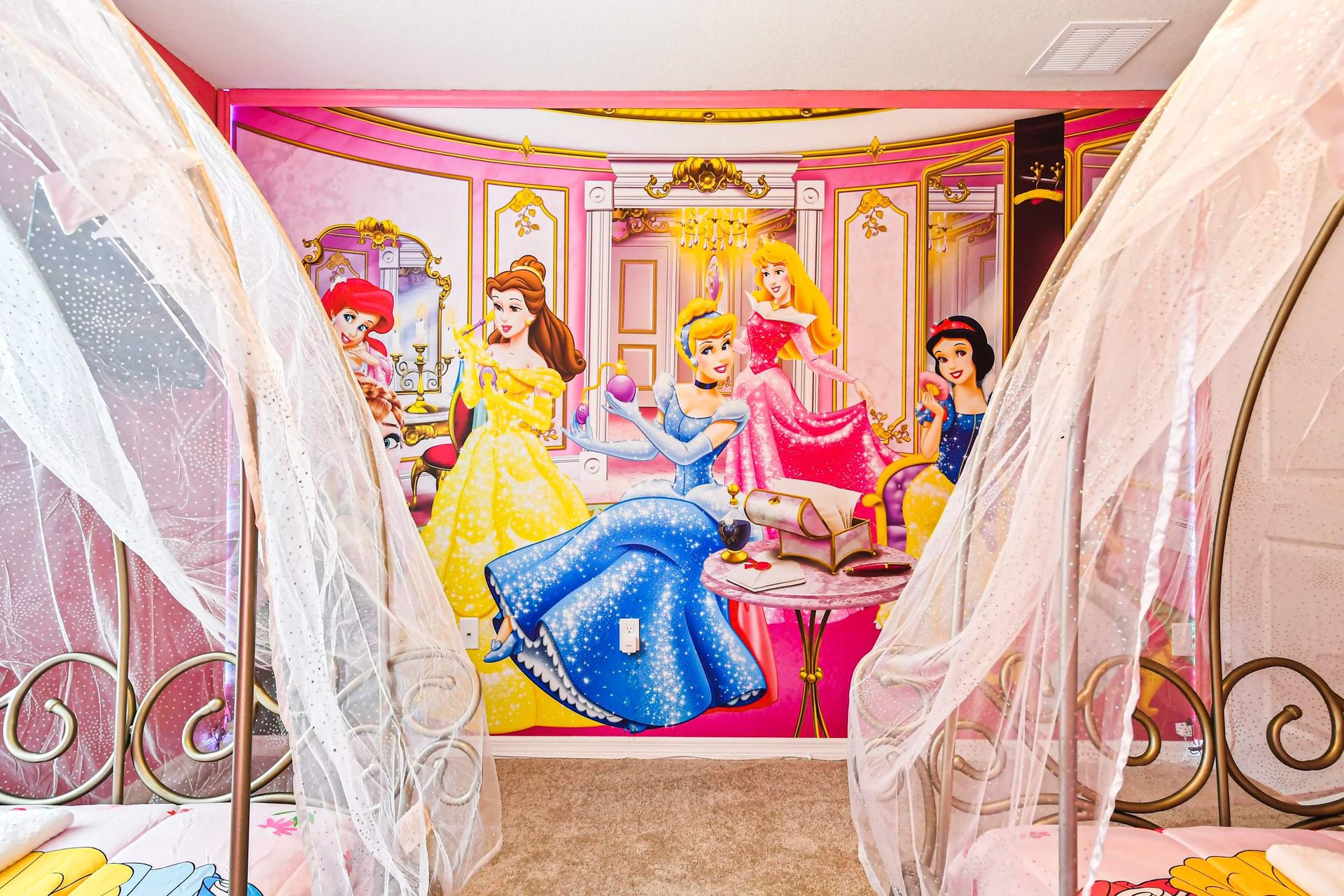 Whimsical princess room with carriage-style beds, pink walls, and royal charm