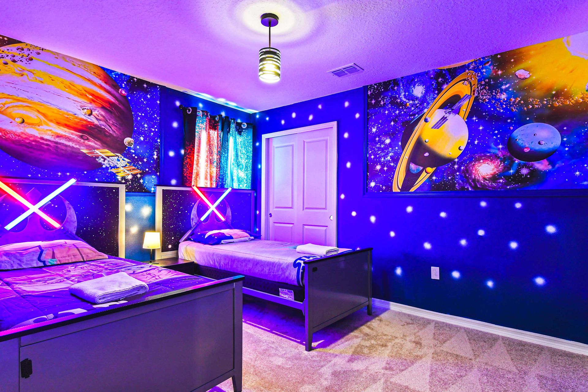 Epic galaxy-themed room with glowing lightsabers, space murals, and twin beds