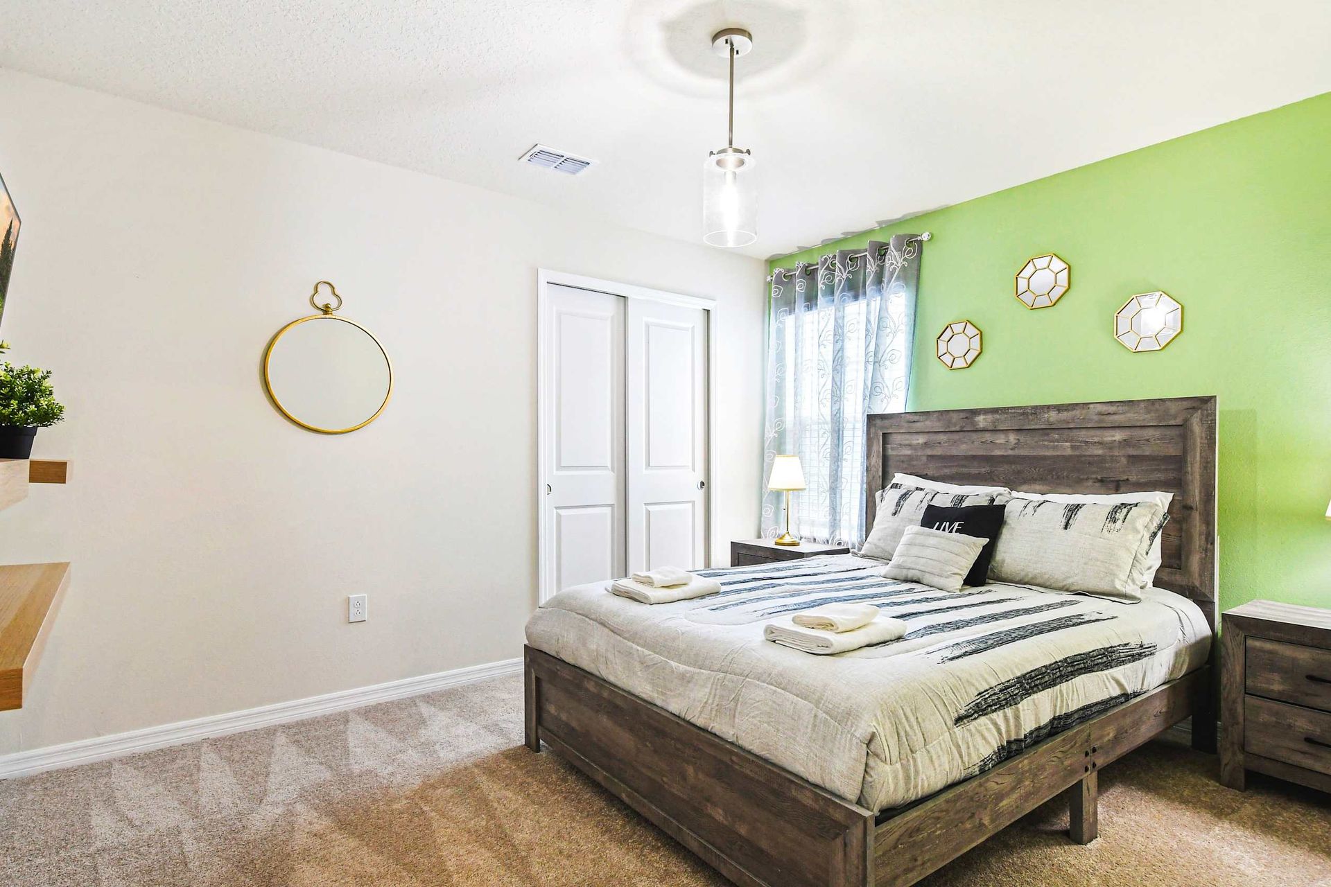 Cozy modern bedroom with rustic wood accents, smart TV, and calming green tones