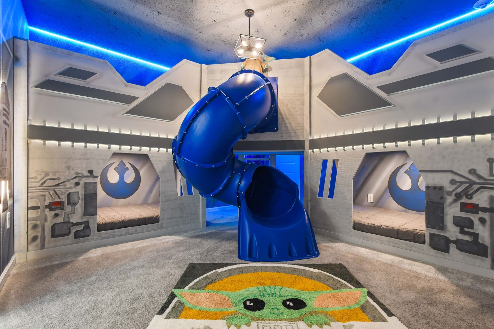 Space-themed room with slide, bunks, and neon lighting for a galactic stay.