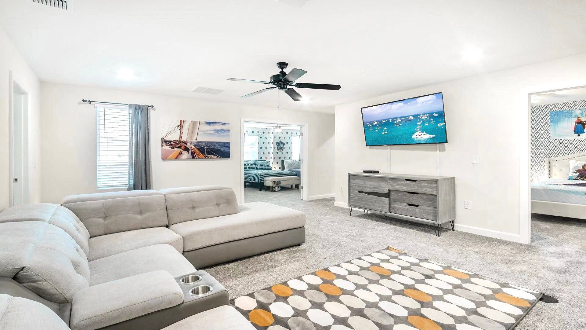 Spacious upstairs lounge with cozy sectional, large TV, and themed bedrooms nearby.