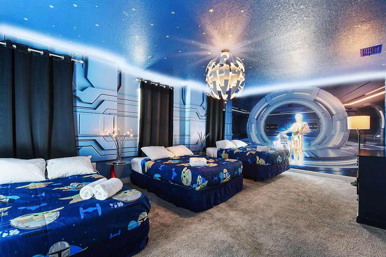 Galactic-themed room with starry decor, cozy beds, and futuristic ambiance.