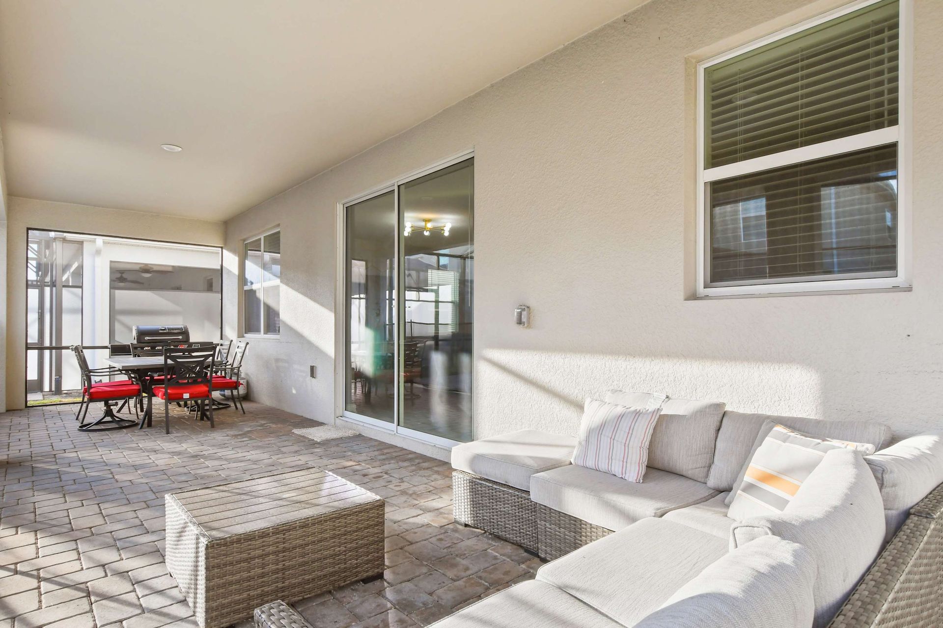 Covered patio with cozy seating, dining area, and BBQ grill!