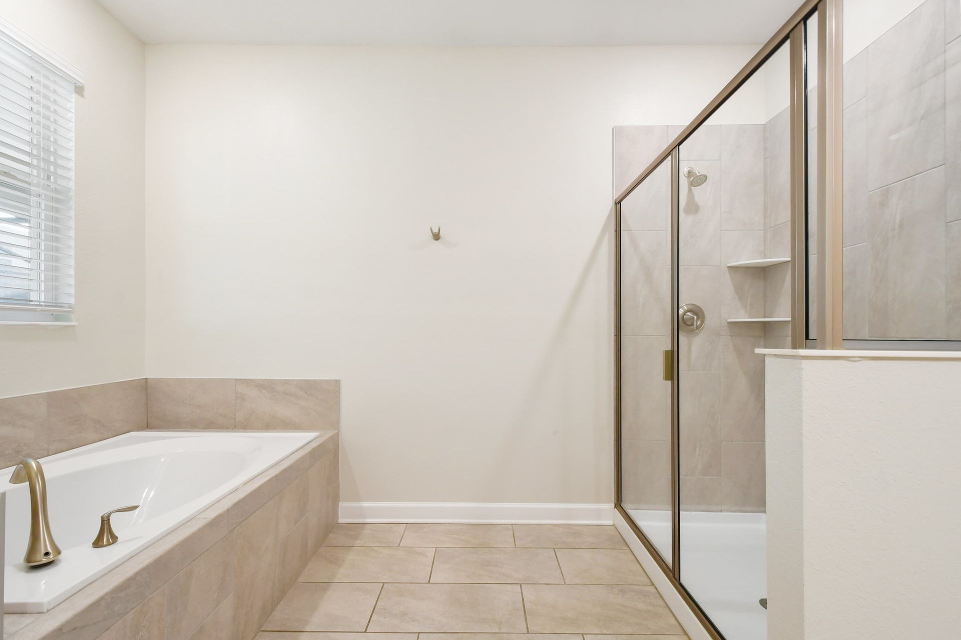 Spacious bathroom with a soaking tub, glass-enclosed shower, and tile accents.
