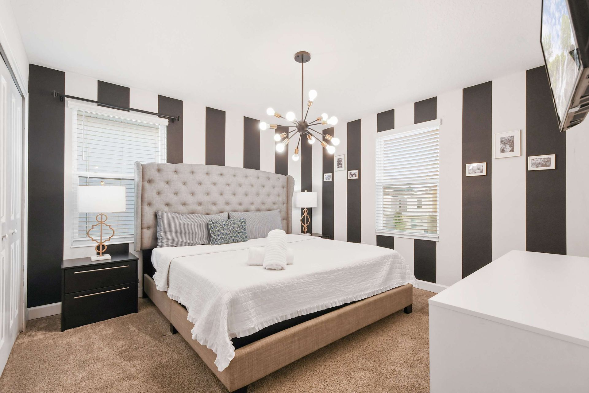 Stylish bedroom with bold striped walls and modern lighting.