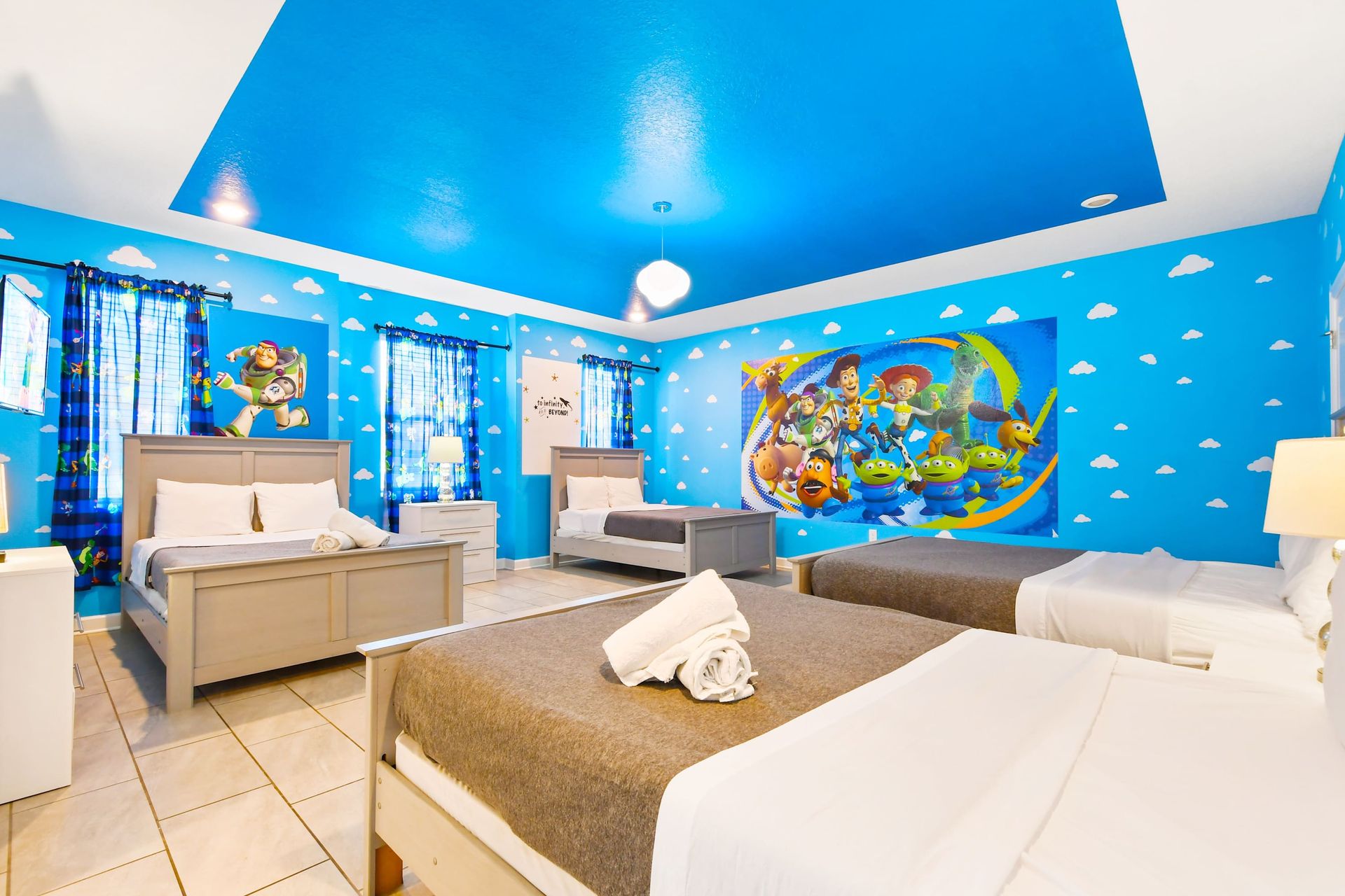 Vibrant Toy Story-themed bedroom with blue walls, cloud accents, and cozy beds.