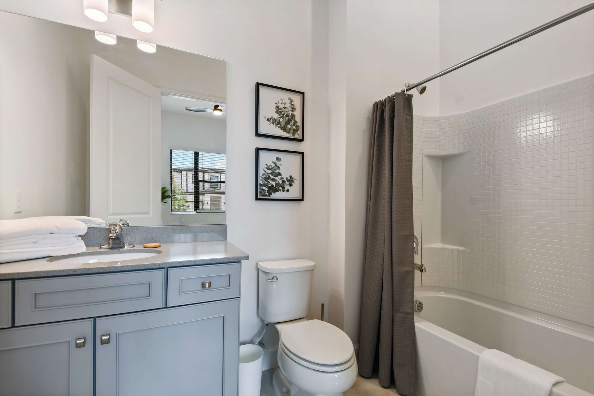 Chic full bathroom with tub, modern vanity, and natural light for a spa-like feel.