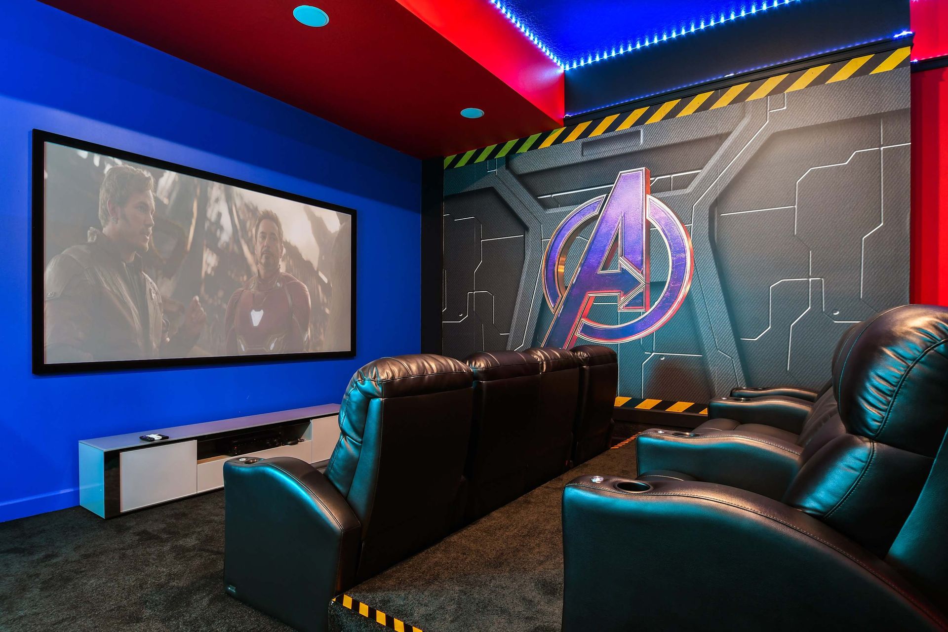 Epic Avengers-themed home theater with leather recliners and massive projection screen.