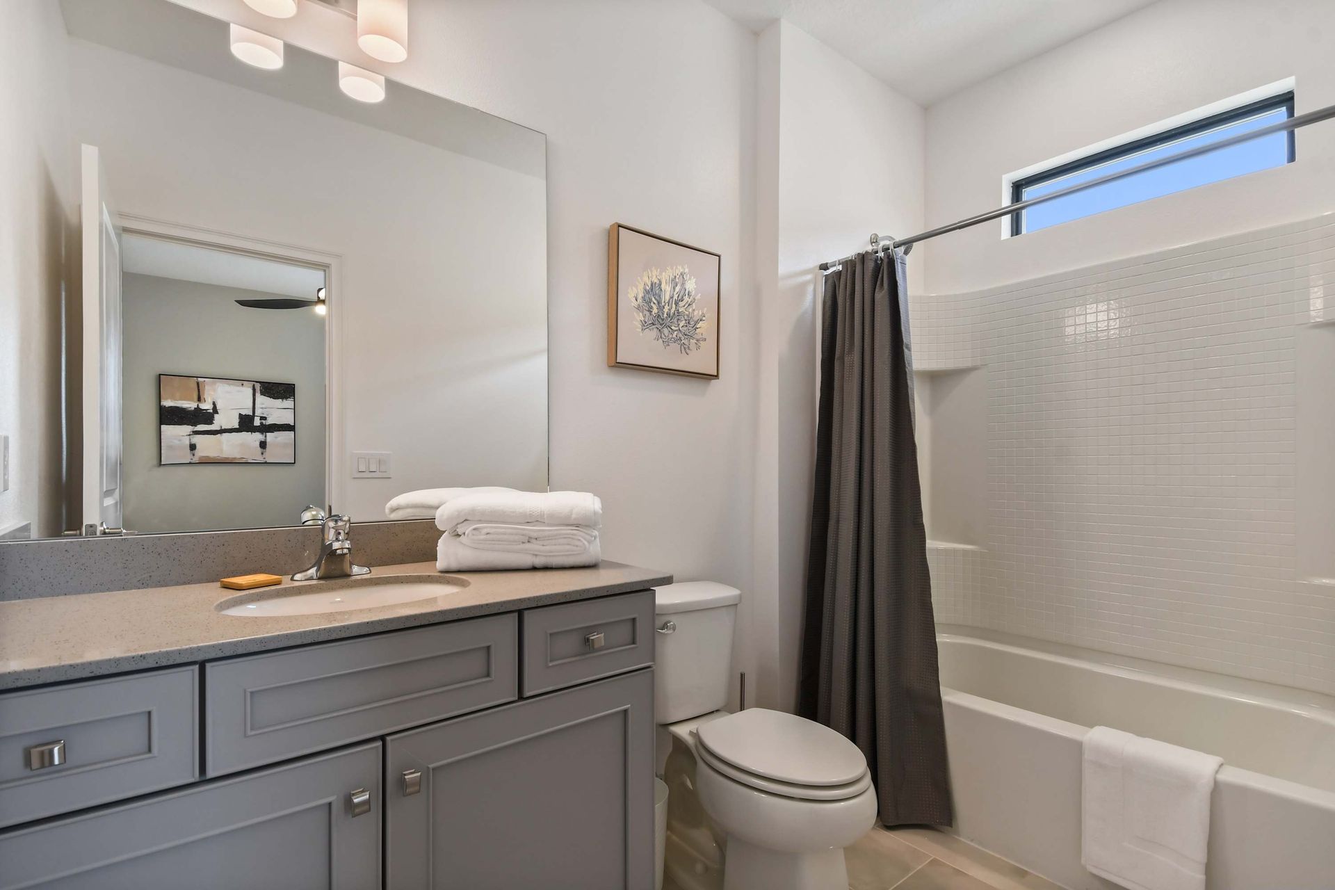 Contemporary bathroom with full tub, soft lighting, and elegant neutral finishes.