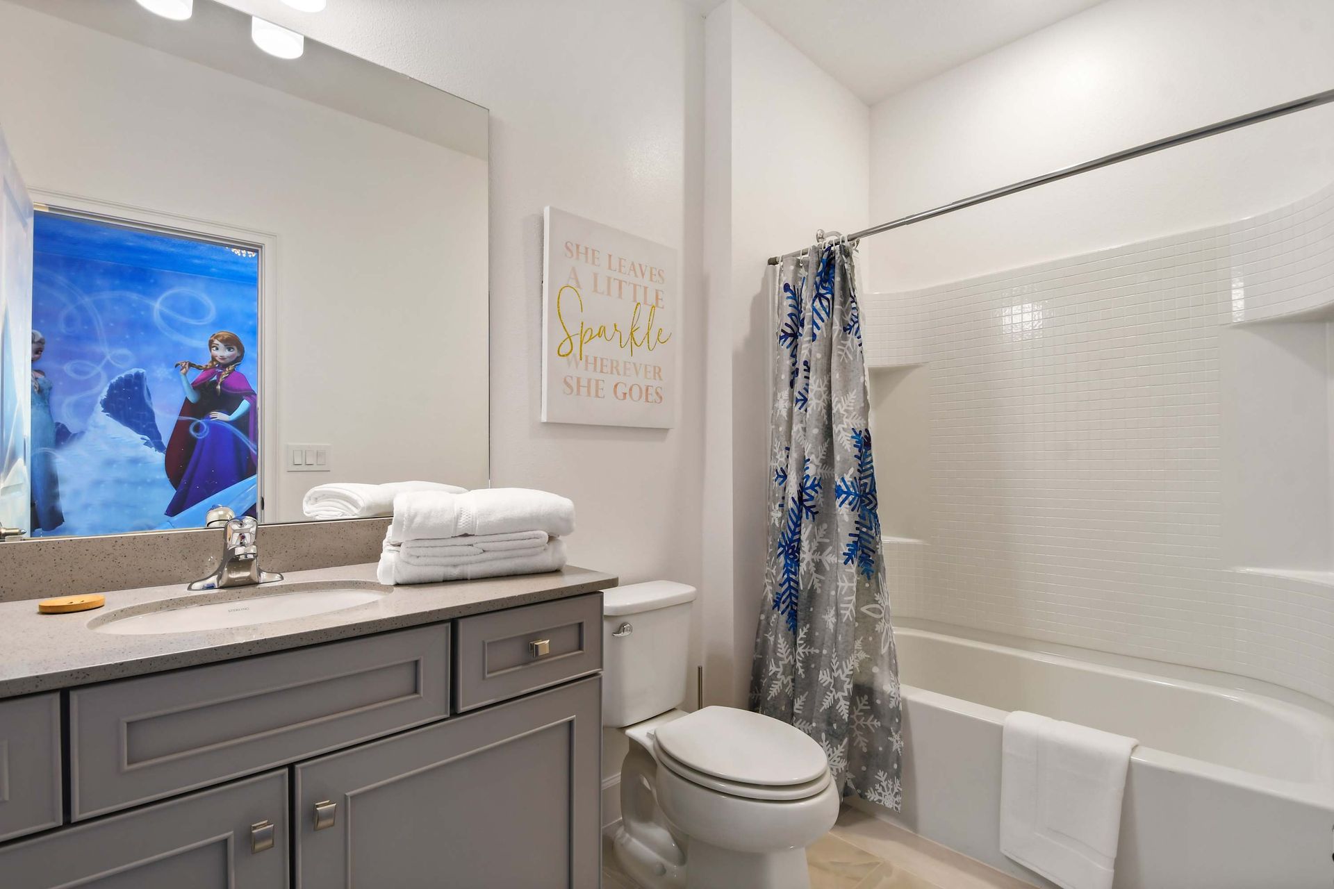Whimsical Frozen-themed bathroom with snowflake accents and a full tub setup.