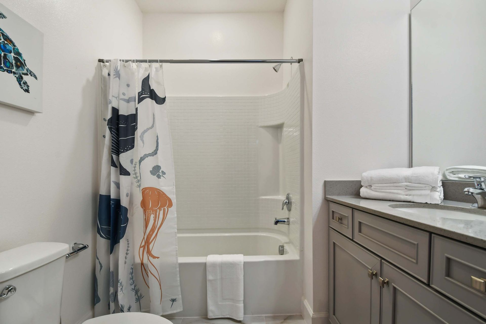 Ocean-themed bathroom with playful sea life decor and a clean, modern vanity setup.