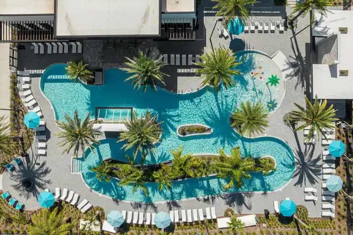 Aerial view of a stunning lazy river, pool, and splash zone in a luxe resort.
