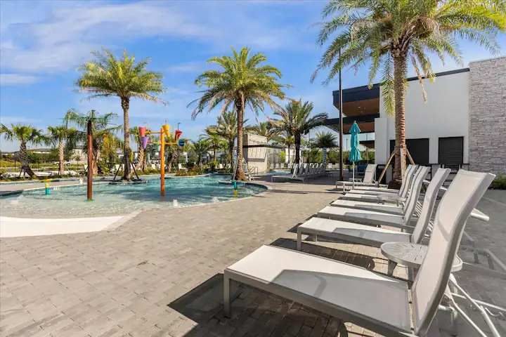 Family-friendly splash zone with lounge chairs, palm trees, and sunny resort vibes.
