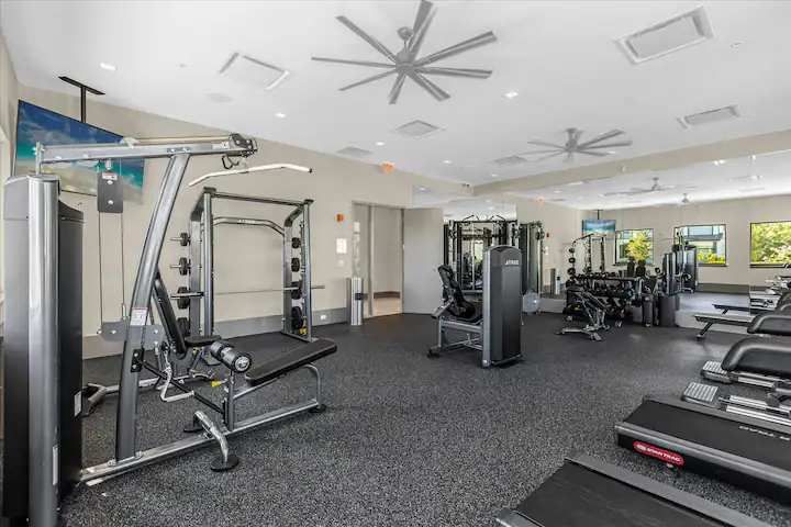 Spacious resort gym with premium equipment, bright lighting, and sleek design.
