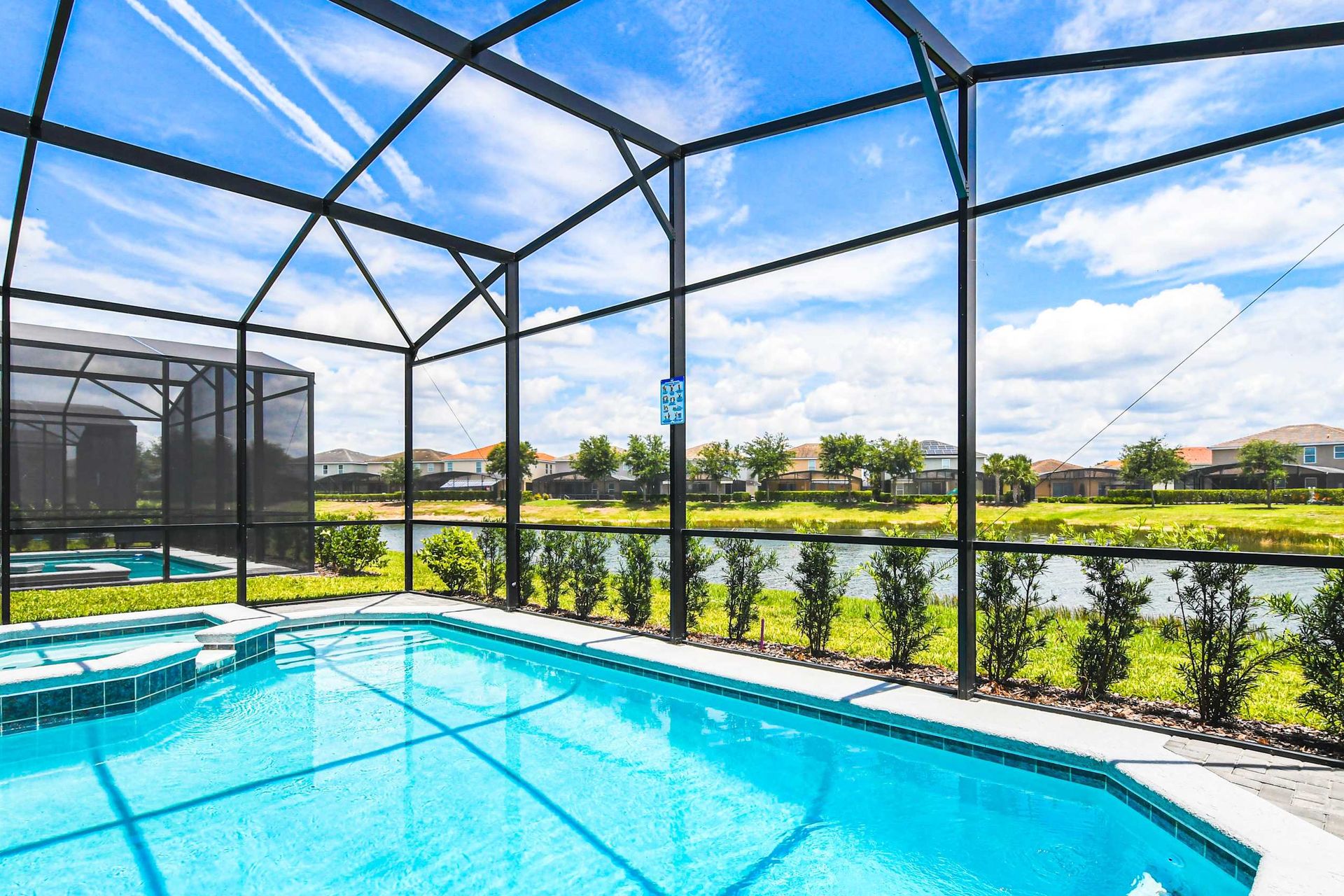 Luxurious screened pool with a stunning lake view, perfect for serene swims and sunny days!