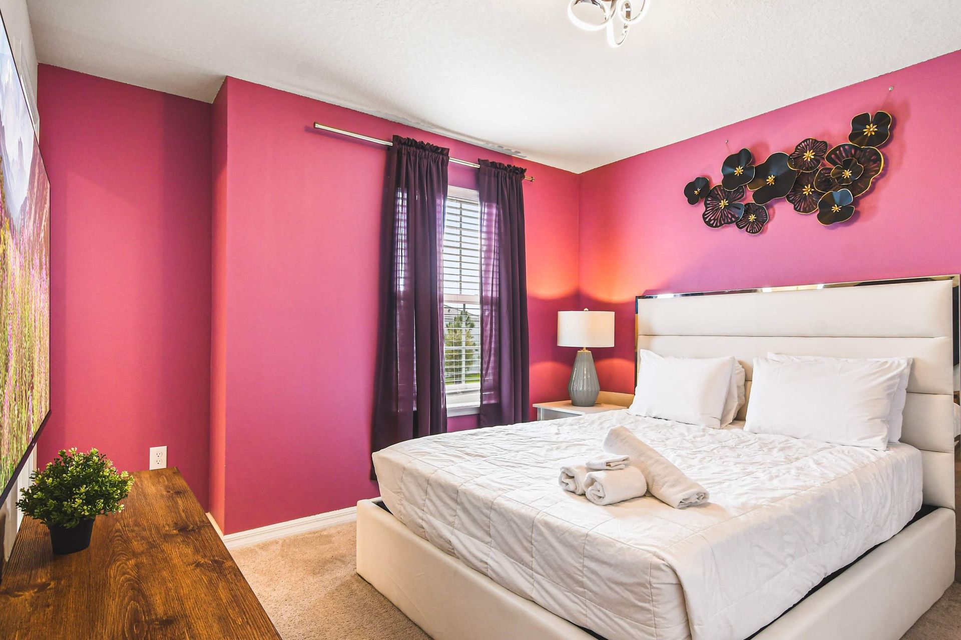 Bold and beautiful! This vibrant pink bedroom boasts stylish accents for a touch of modern glamour and coziness.