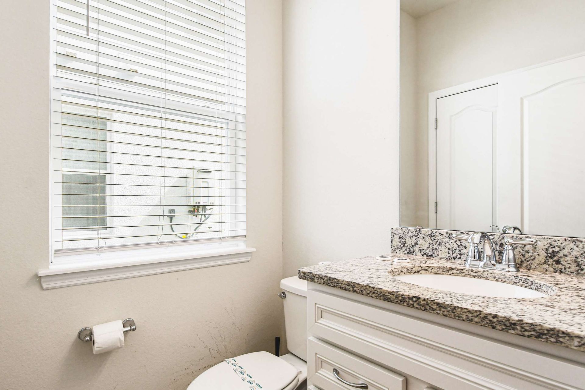 Bright and clean bathroom with elegant granite countertops and a serene view, perfect for refreshing mornings.