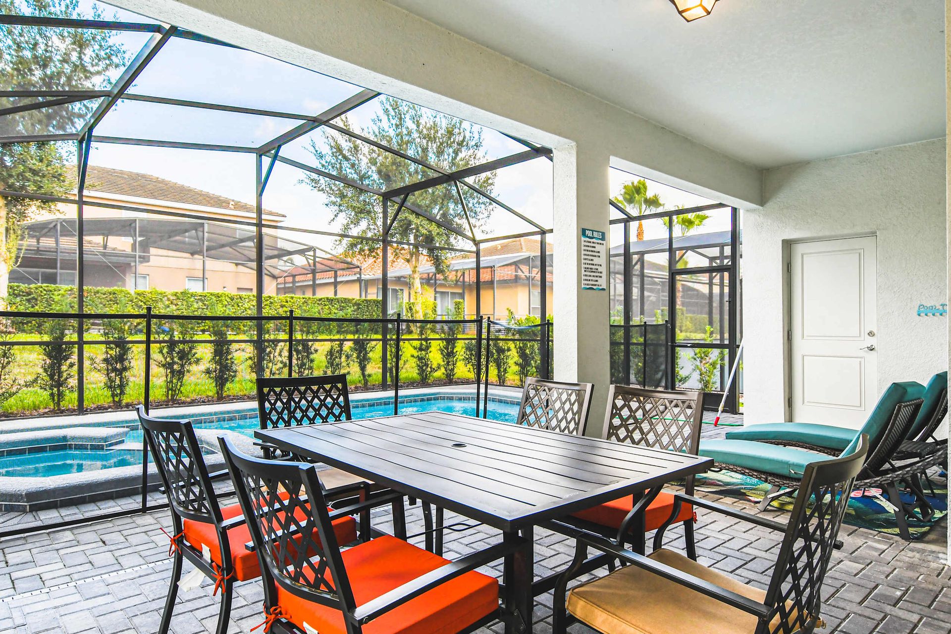 Enjoy alfresco dining by the pool in this screened patio area, perfect for gatherings or a peaceful evening retreat.