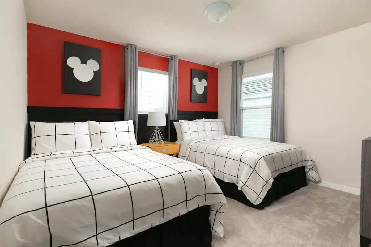 Modern Mickey-inspired room with two full beds and cozy, playful touches throughout.