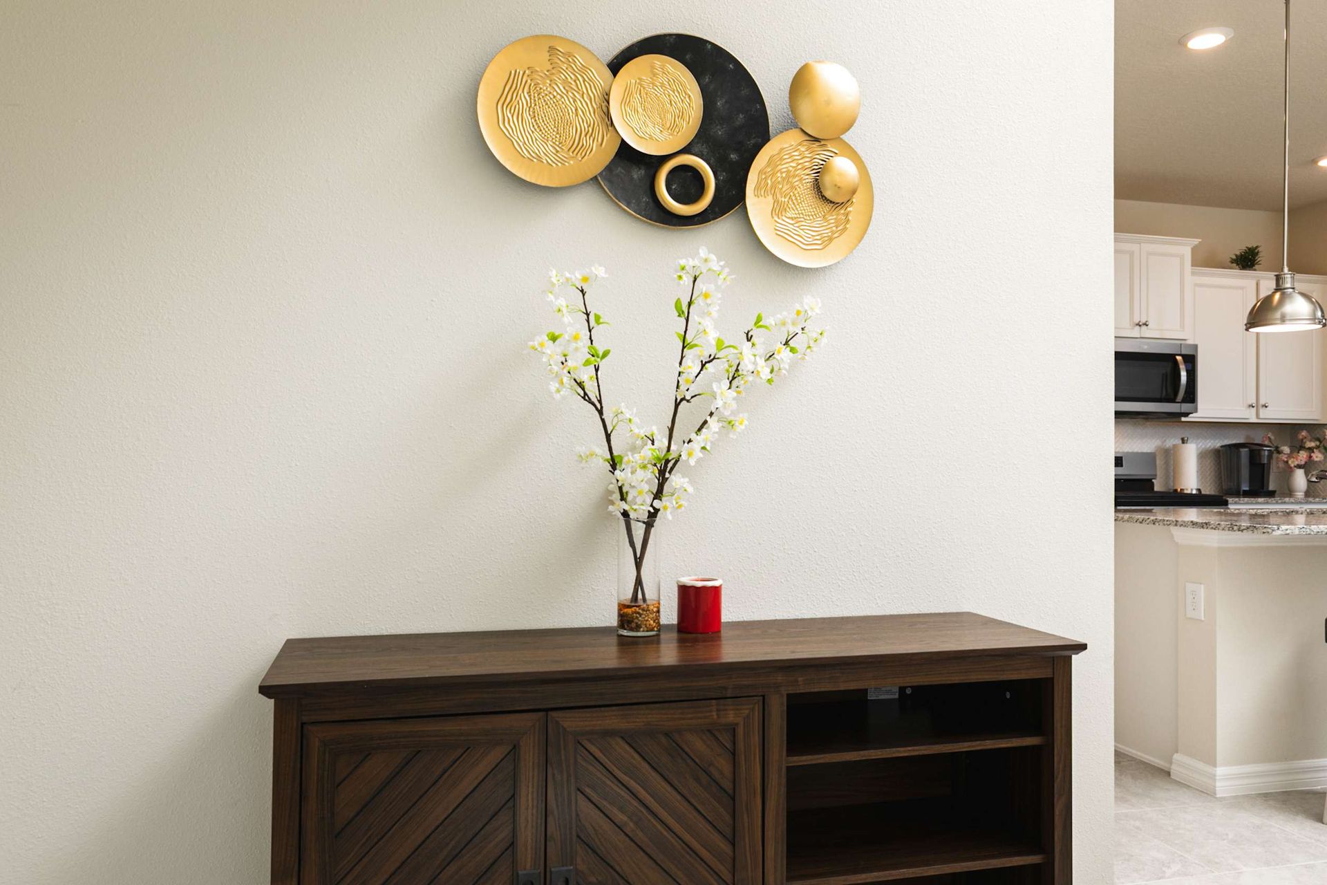 Artful gold accents and fresh florals define this sophisticated, light-filled living space.