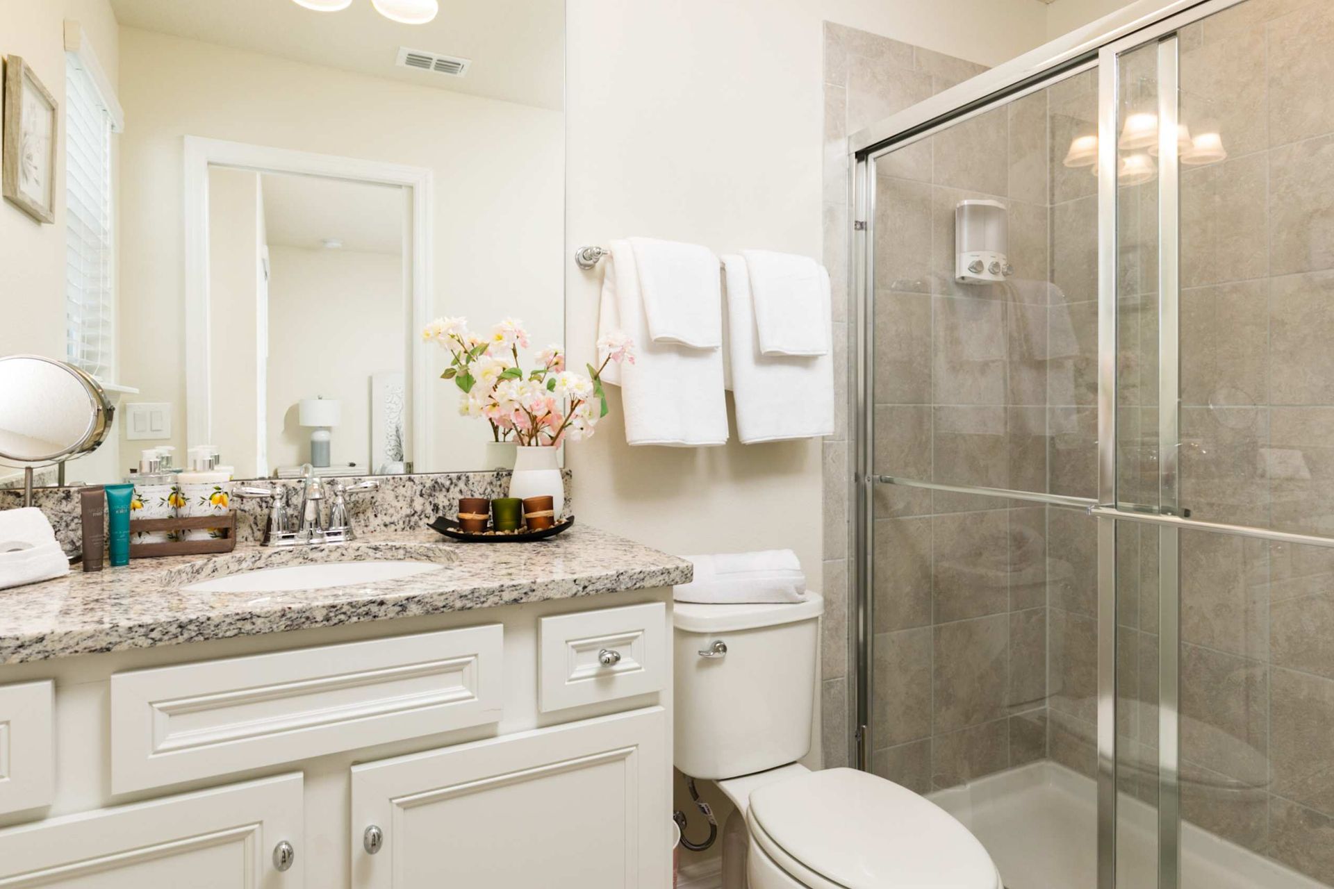 Indulge in this spa-like retreat featuring a granite vanity and elegant glass-enclosed shower.