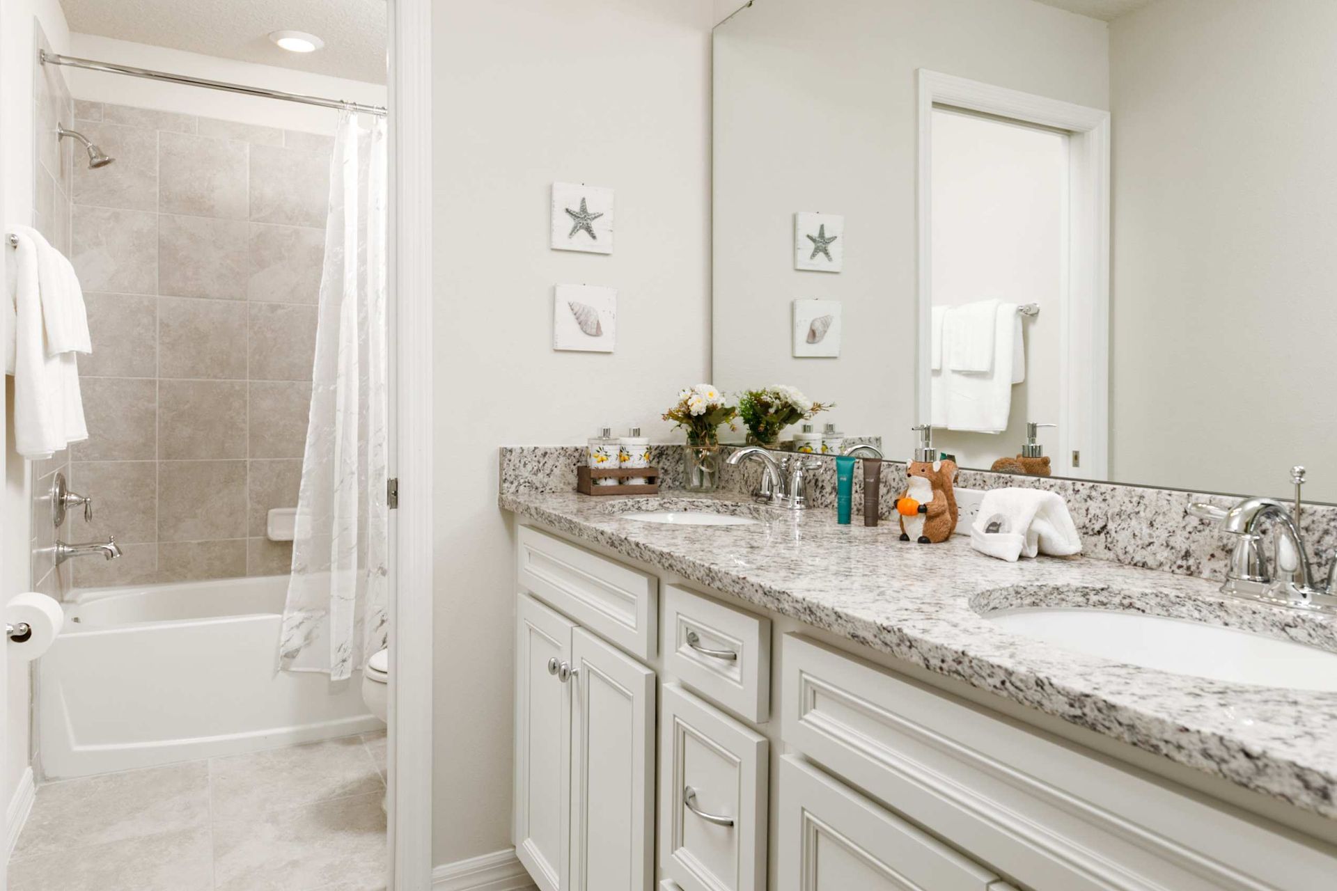 Indulge in tranquility with this master bath's granite dual vanity and pristine spa-like finishes.