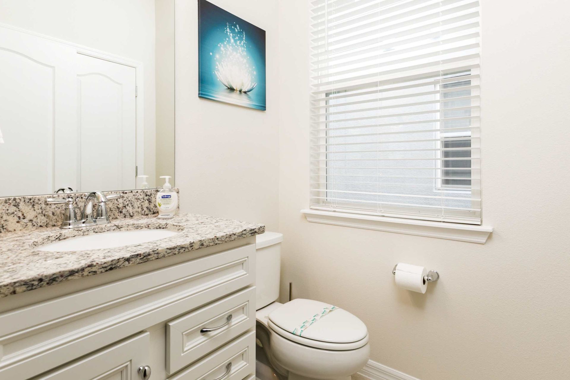 Elegant bathroom retreat with granite accents and natural light for a refreshing morning routine.