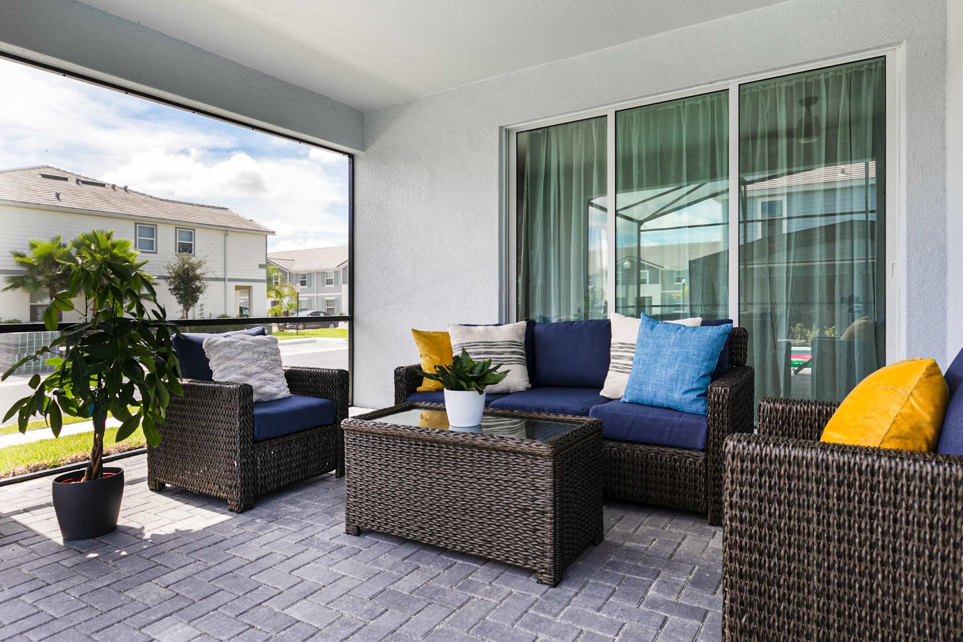 Unwind in this chic screened patio, blending modern wicker comfort with serene outdoor views.