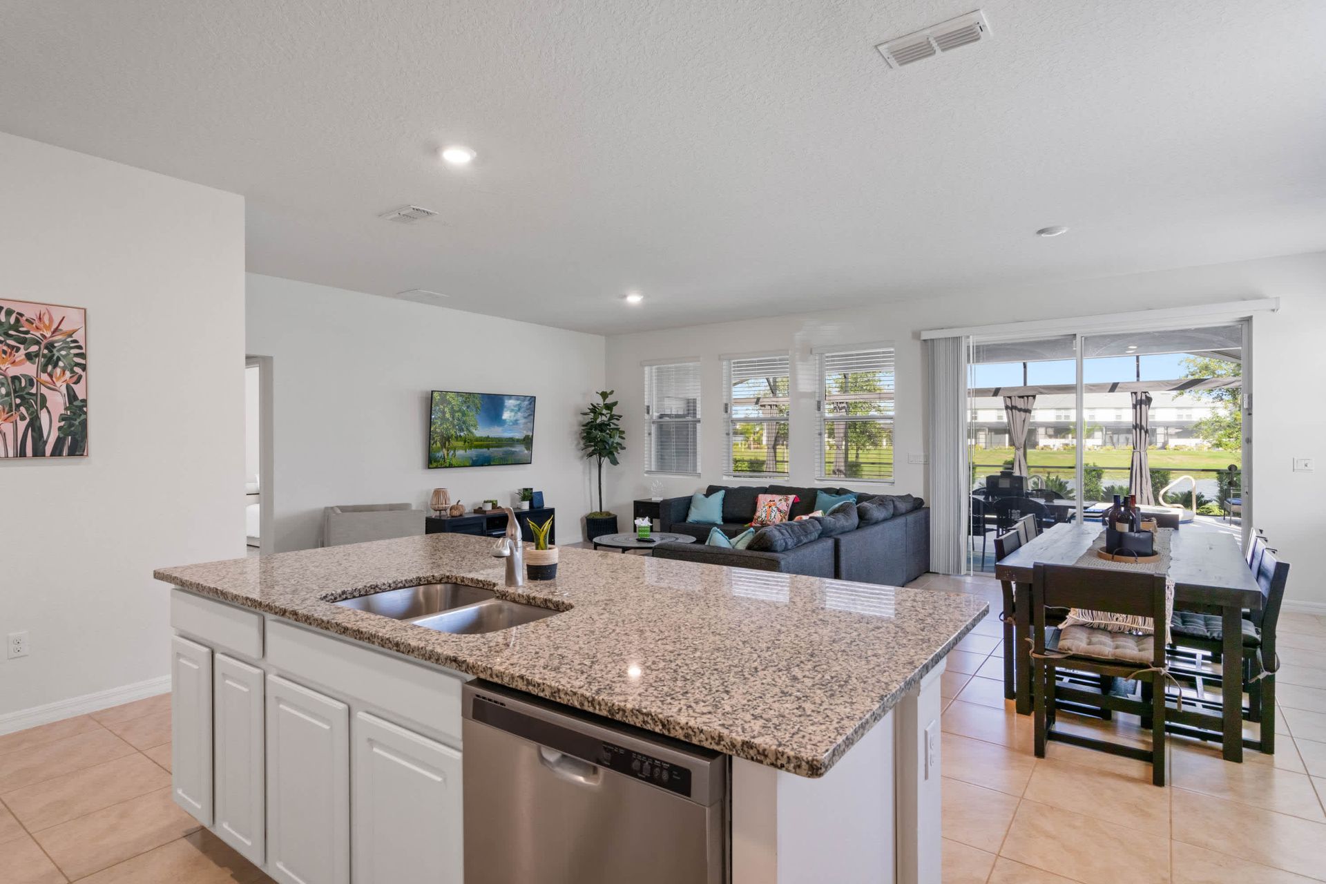 Bright open kitchen with granite island, seamless flow to dining and living space.