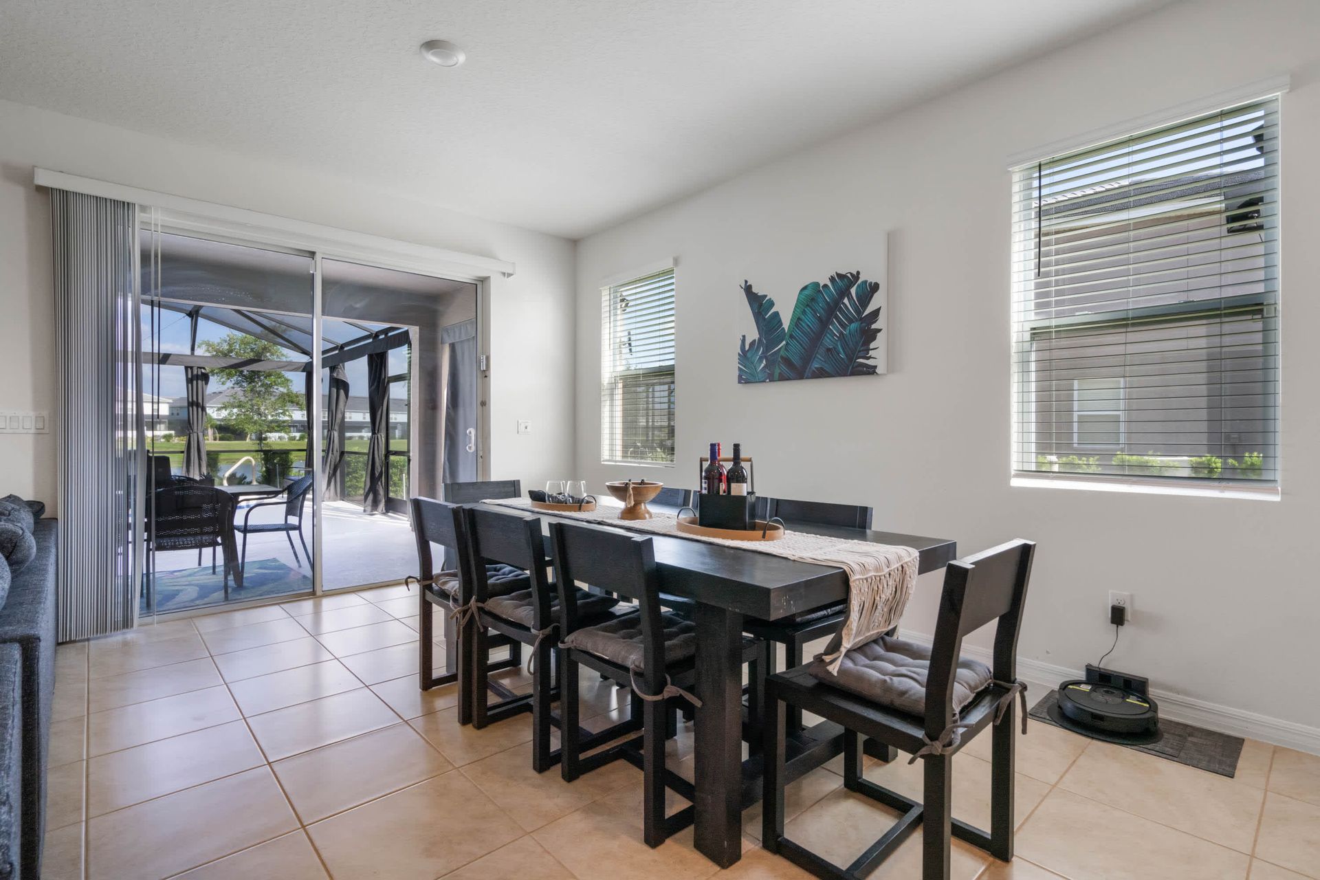 Sunny dining area with seating for eight, stylish decor, and poolside access.