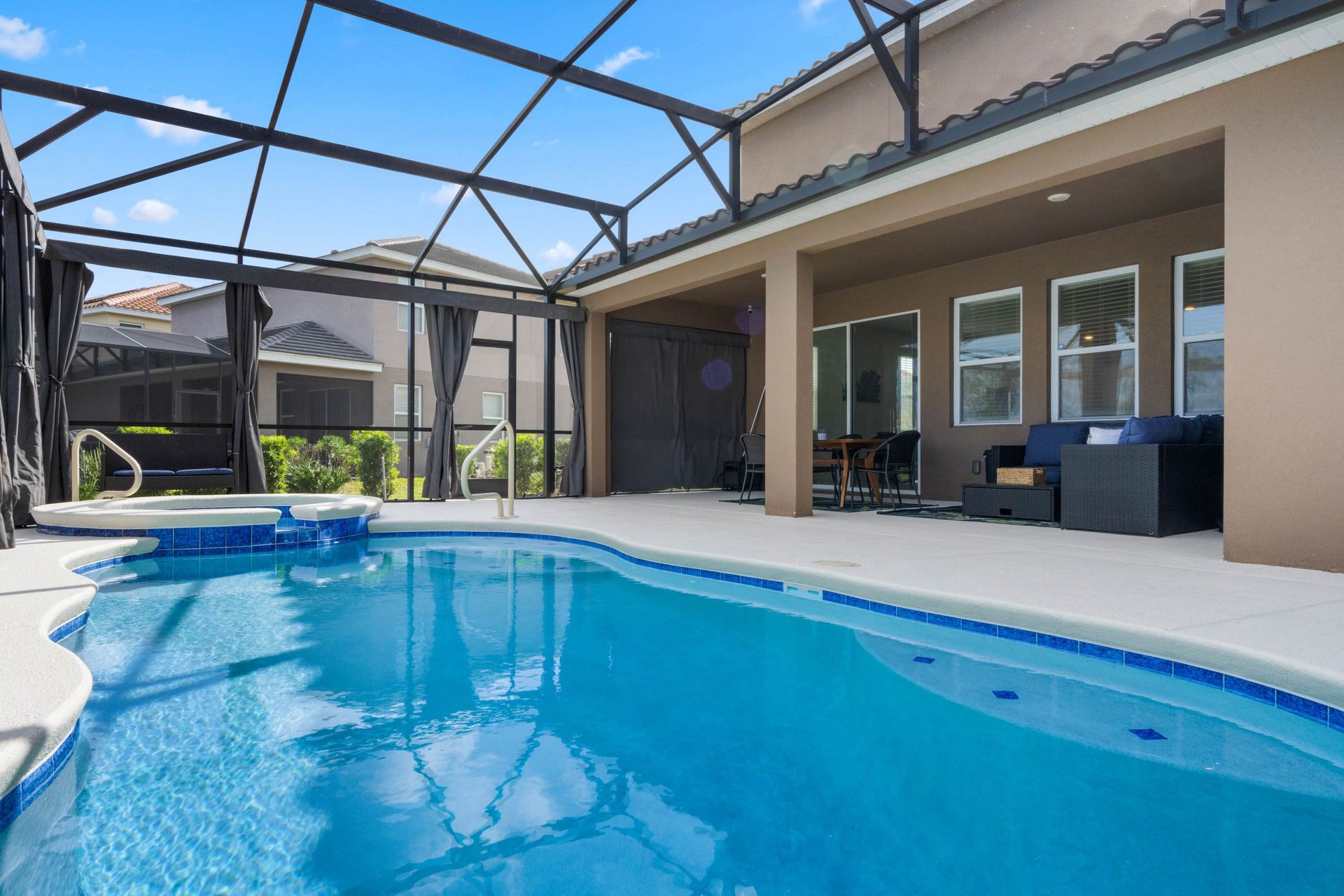 Private screened pool and spa with shaded lounge, dining area, and sunny vibes.