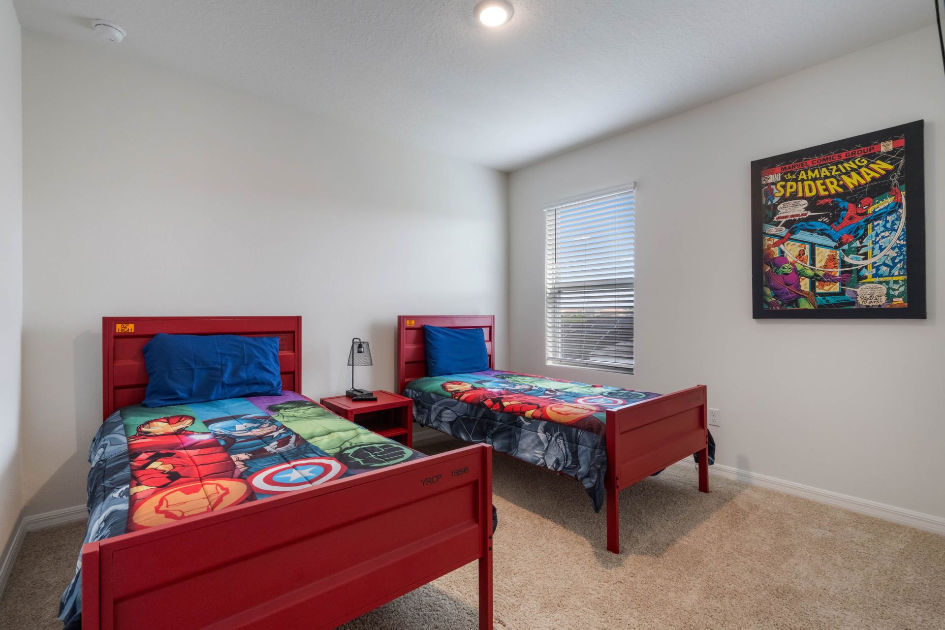 Vibrant kids' room with twin superhero beds, cozy carpet, and comic wall art.