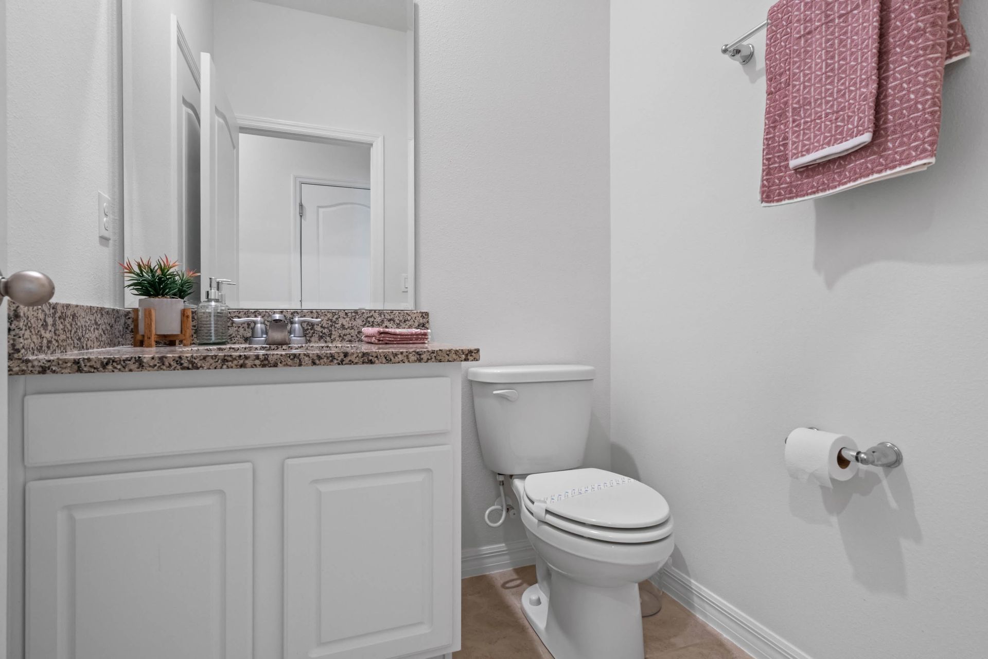 Chic half bath with granite vanity, modern fixtures, and a pop of color.