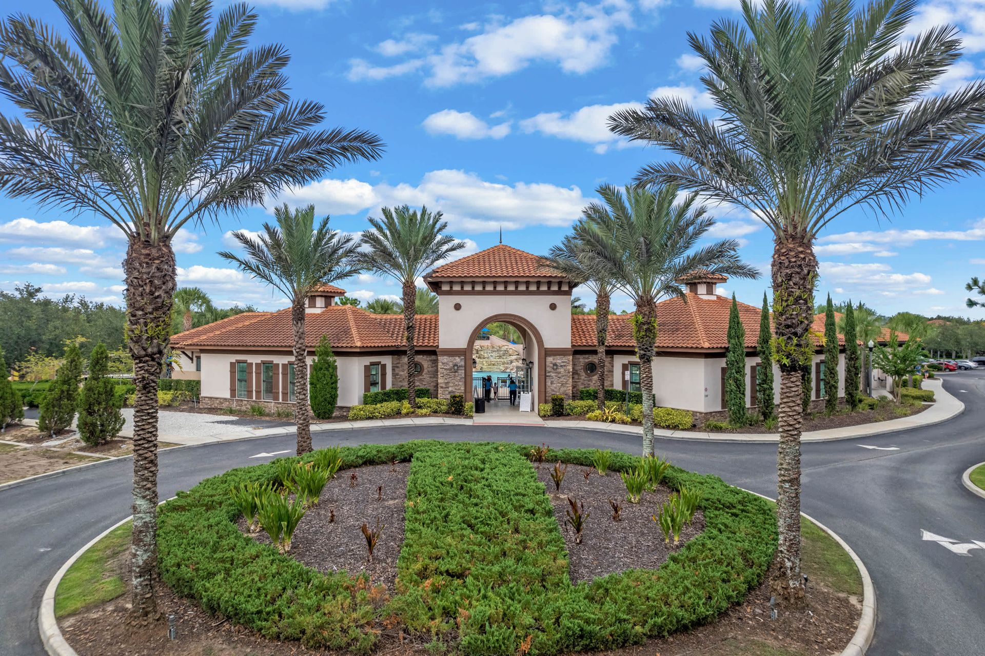 Resort-style gated community with luxury amenities and palm-lined entrance
