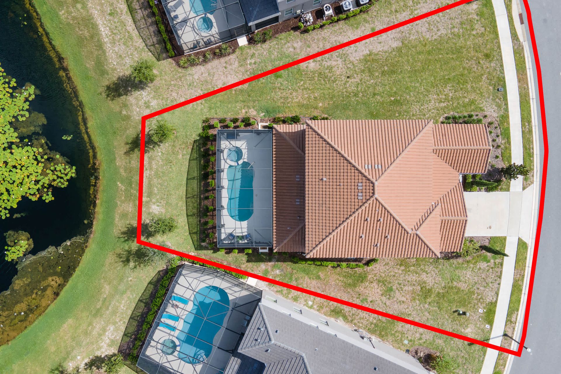 Expansive corner-lot home with private screened pool and serene water views.