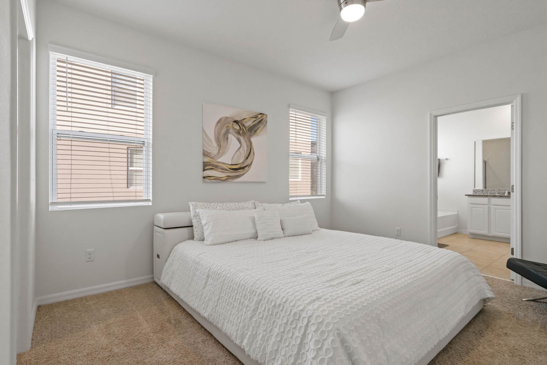 Bright and elegant bedroom with king bed, ensuite bathroom, and soft neutral tones.
