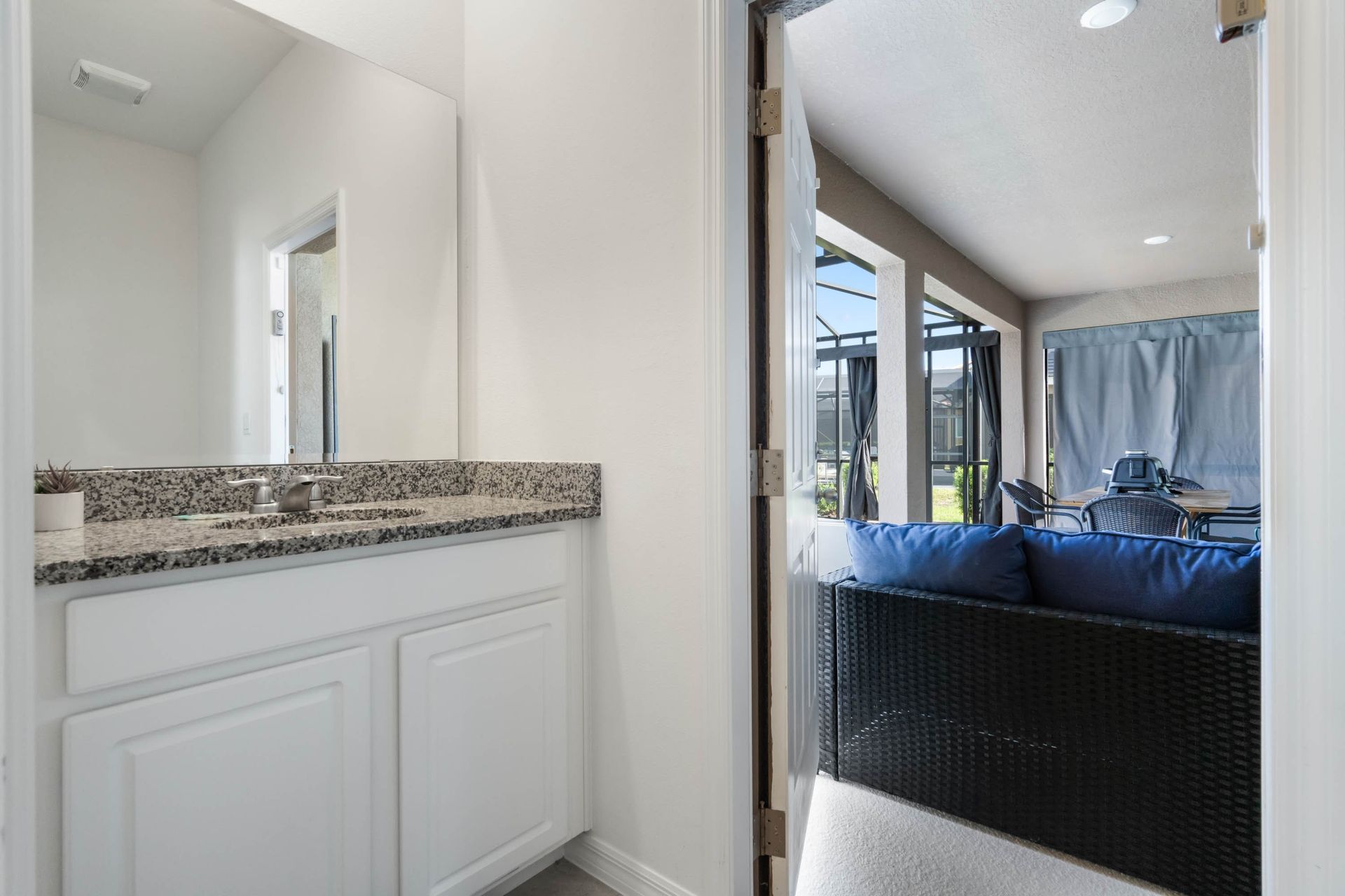 Convenient poolside half bath with granite vanity and direct access to the lanai.