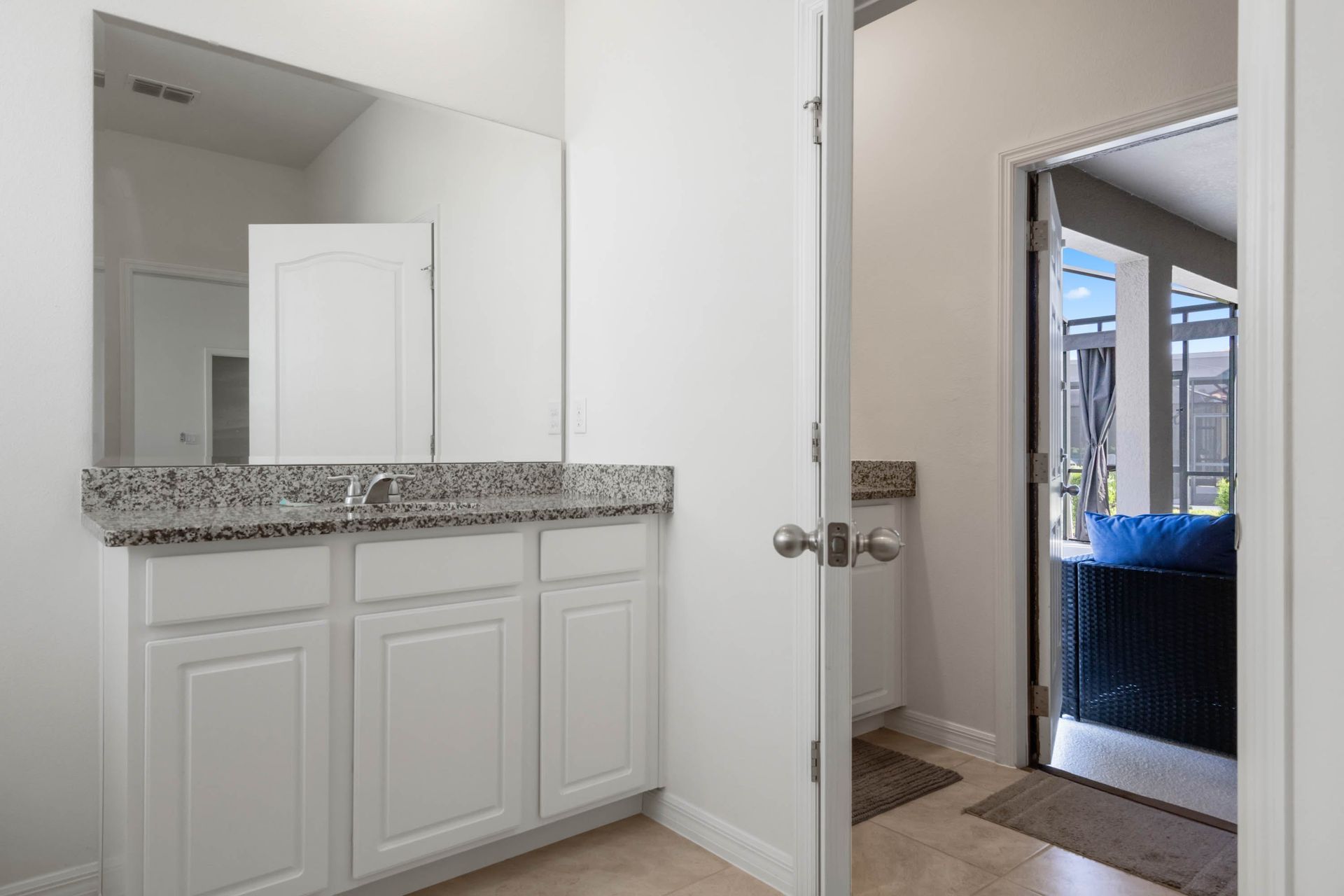Bright poolside bathroom with granite vanity and direct access to the outdoor lounge.