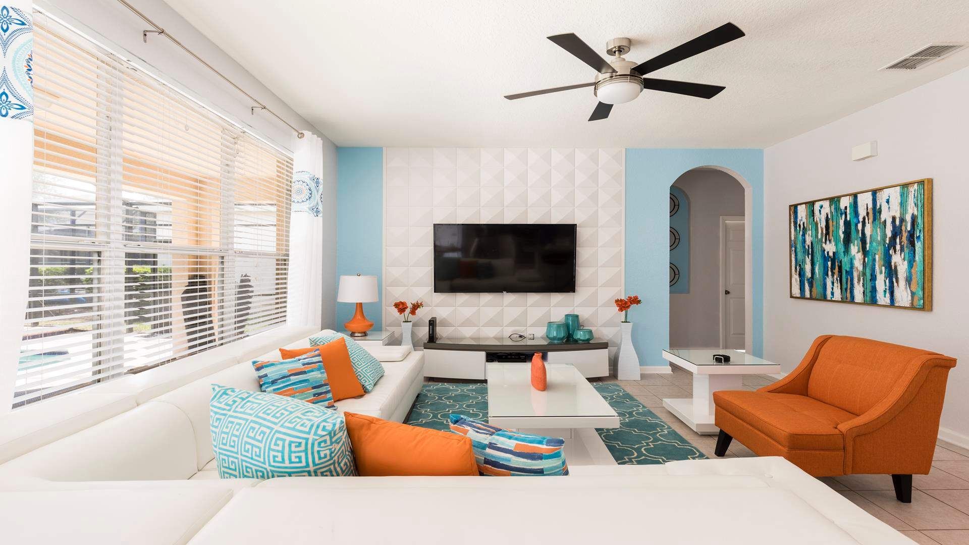 Chill out in style! This living room features a comfy couch, a mounted TV for movie marathons, and a ceiling fan to keep you cool.