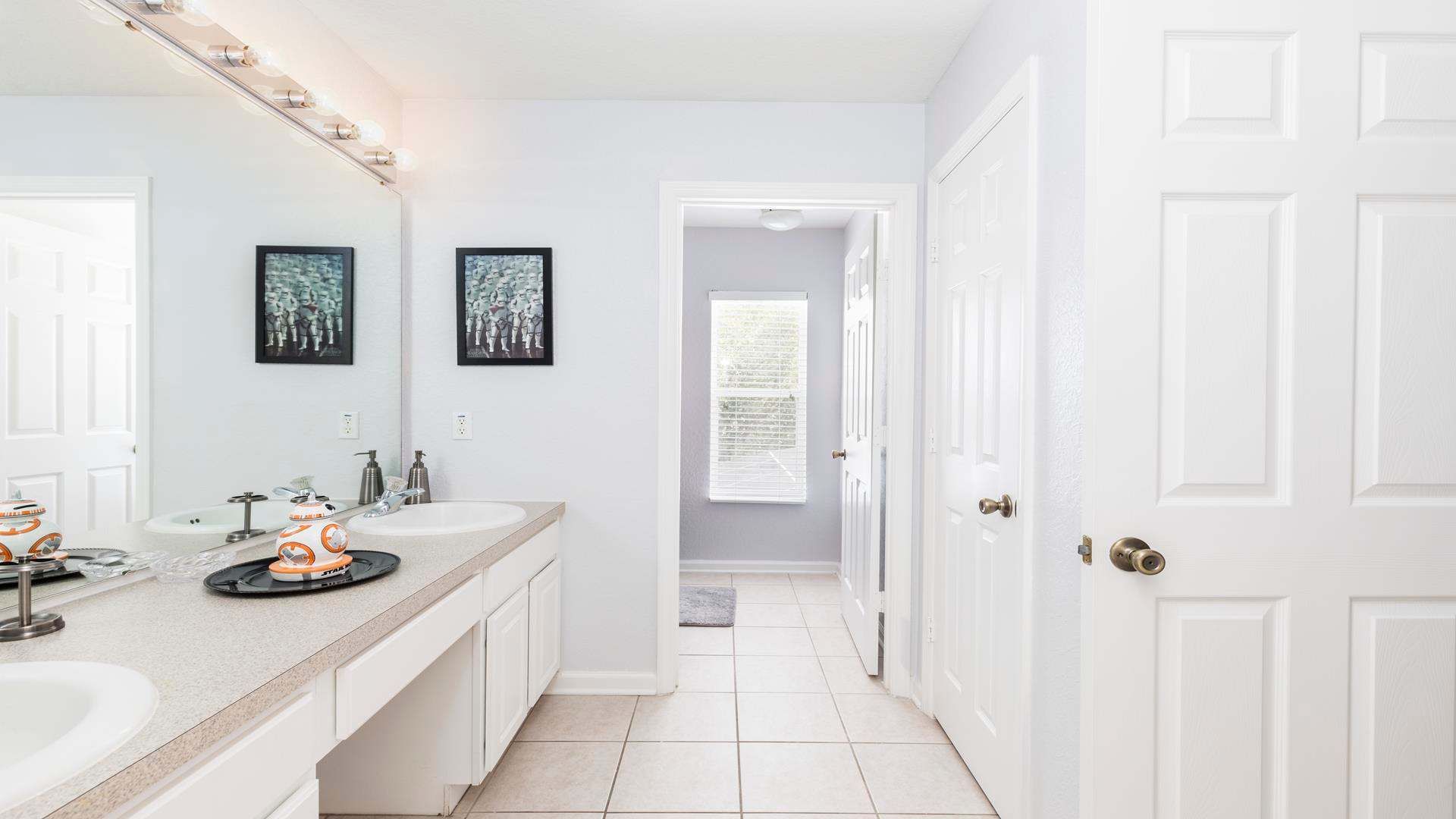 Spacious and bright bathroom with dual sinks, modern decor, and a sleek design.