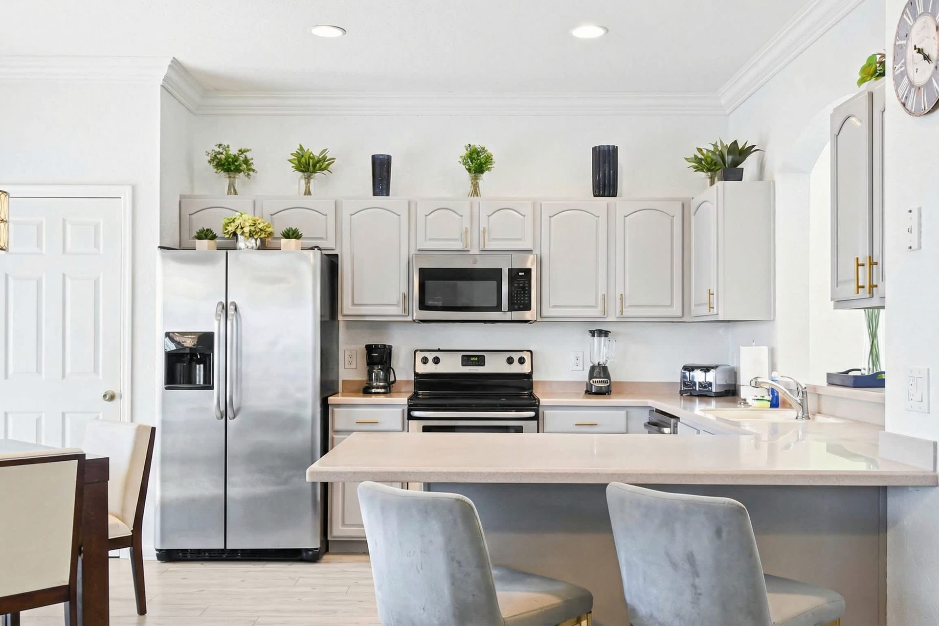 Modern kitchen with stainless steel appliances, breakfast bar, and bright decor.